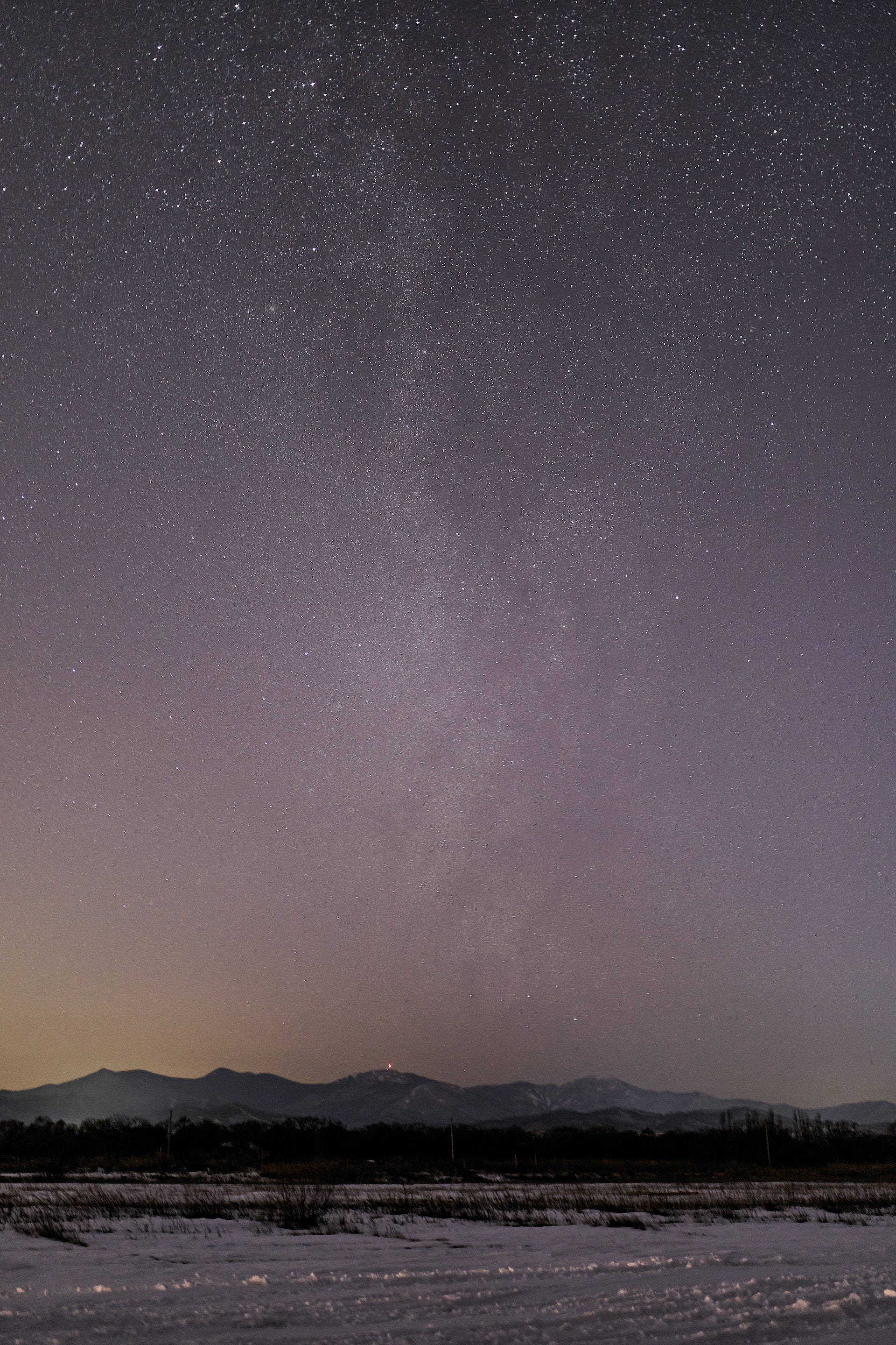 Night Aesthetic 桌布 壁紙 — 雪地田野，星空下，銀河拱跨遠山。