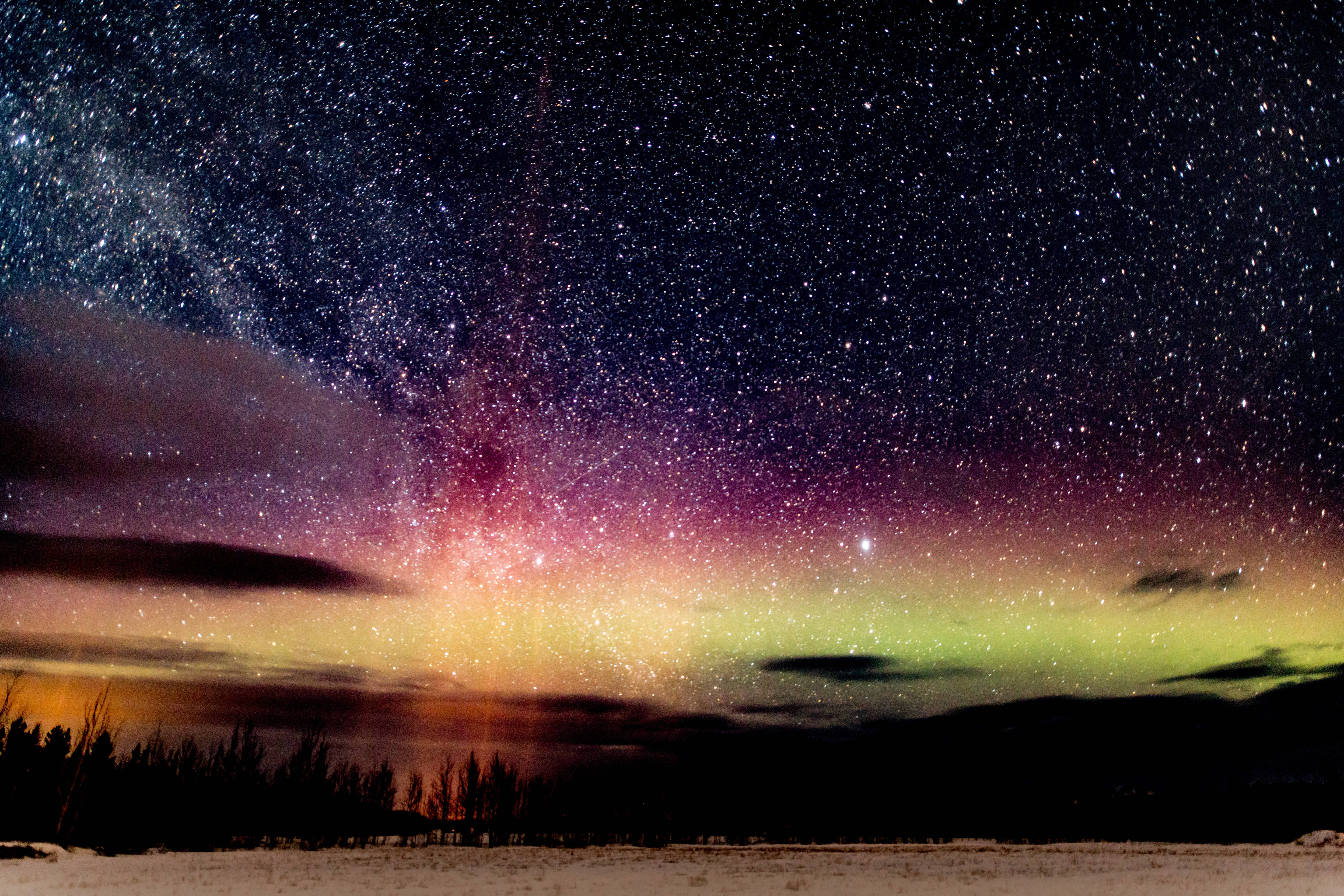 Starry 桌布 壁紙 — 雪景仰望充滿活力的極光和星空，帶有紫色、粉紅色和綠色色調。