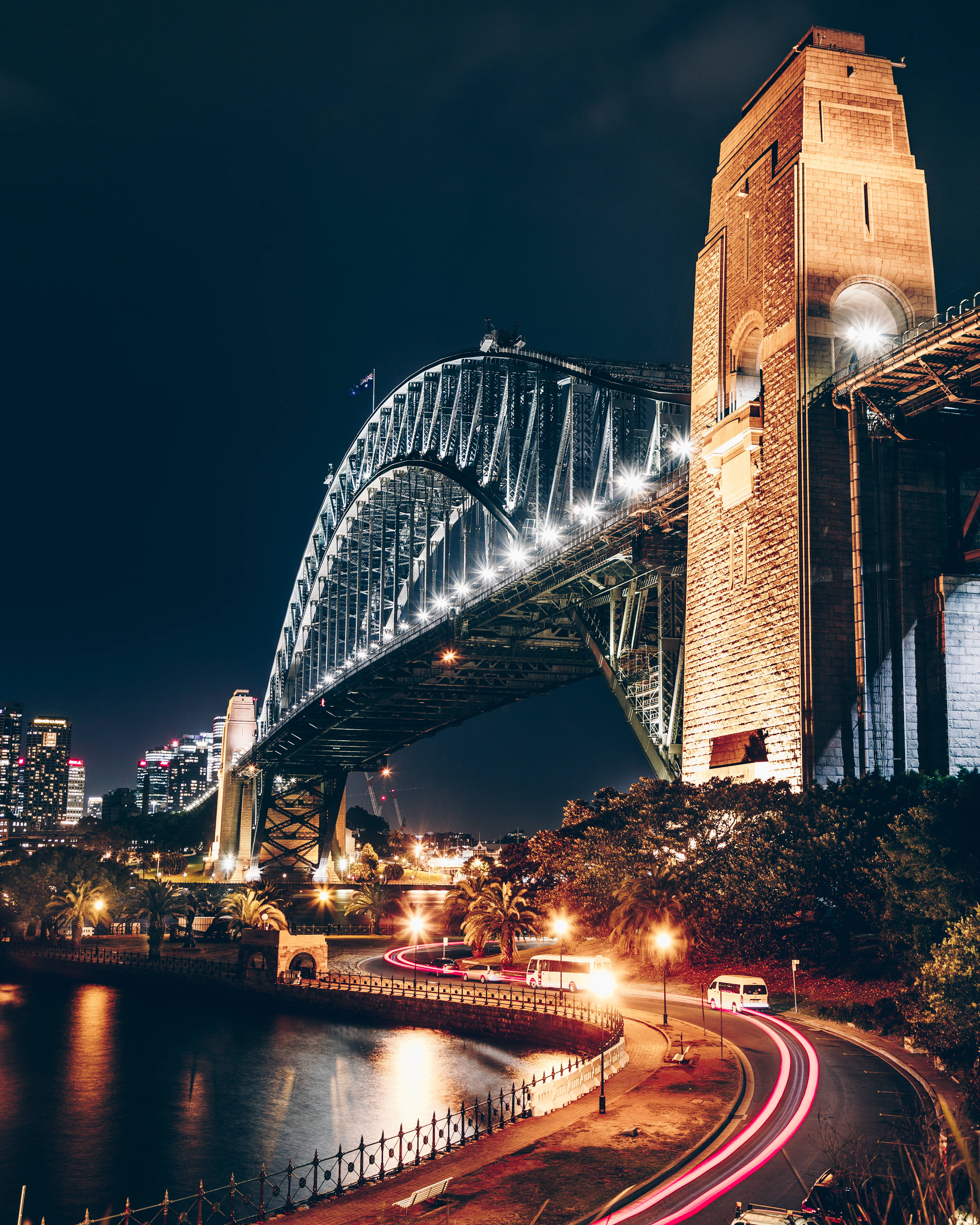 Sydney 桌布 壁紙 — 雪梨港灣大橋在黑暗天空下亮燈的壯麗夜景，下方有移動車輛的光軌。