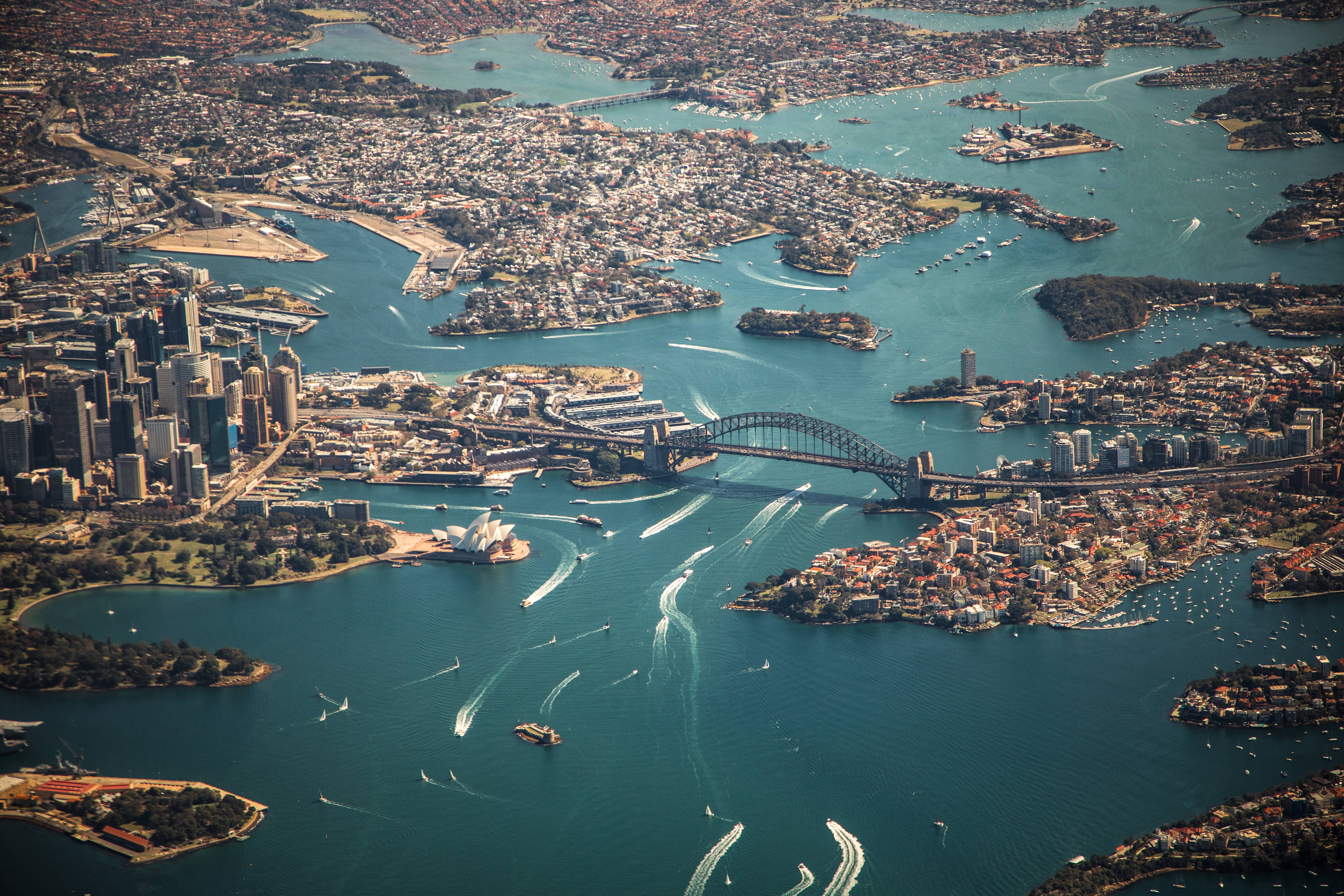 Sydney 桌布 壁紙 — 雪梨港的鳥瞰圖，港灣大橋和歌劇院被碧綠的海水和繁華的城市景觀環繞。