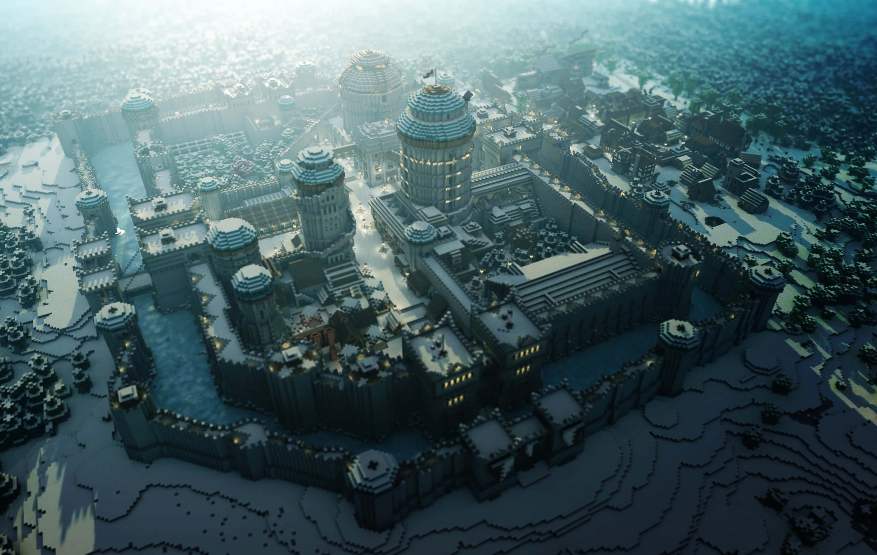 Minecraft City 桌布 壁紙 — 雪覆蓋的宏偉奇幻城堡建築群的鳥瞰圖，發光的窗戶和冰護城河環繞著冰凍的景觀。