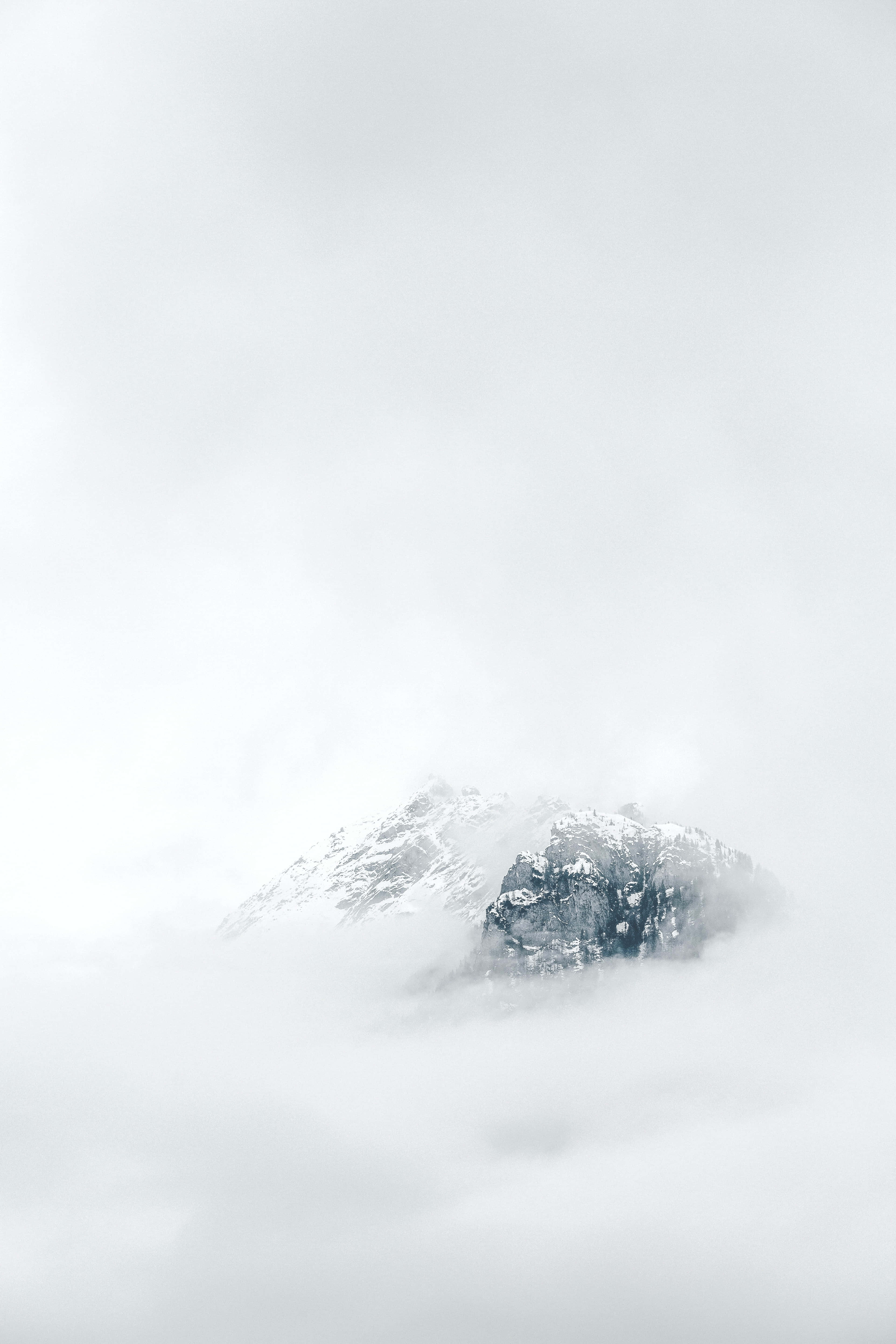 雲霧籠罩的山峰，山頂積雪 壁紙