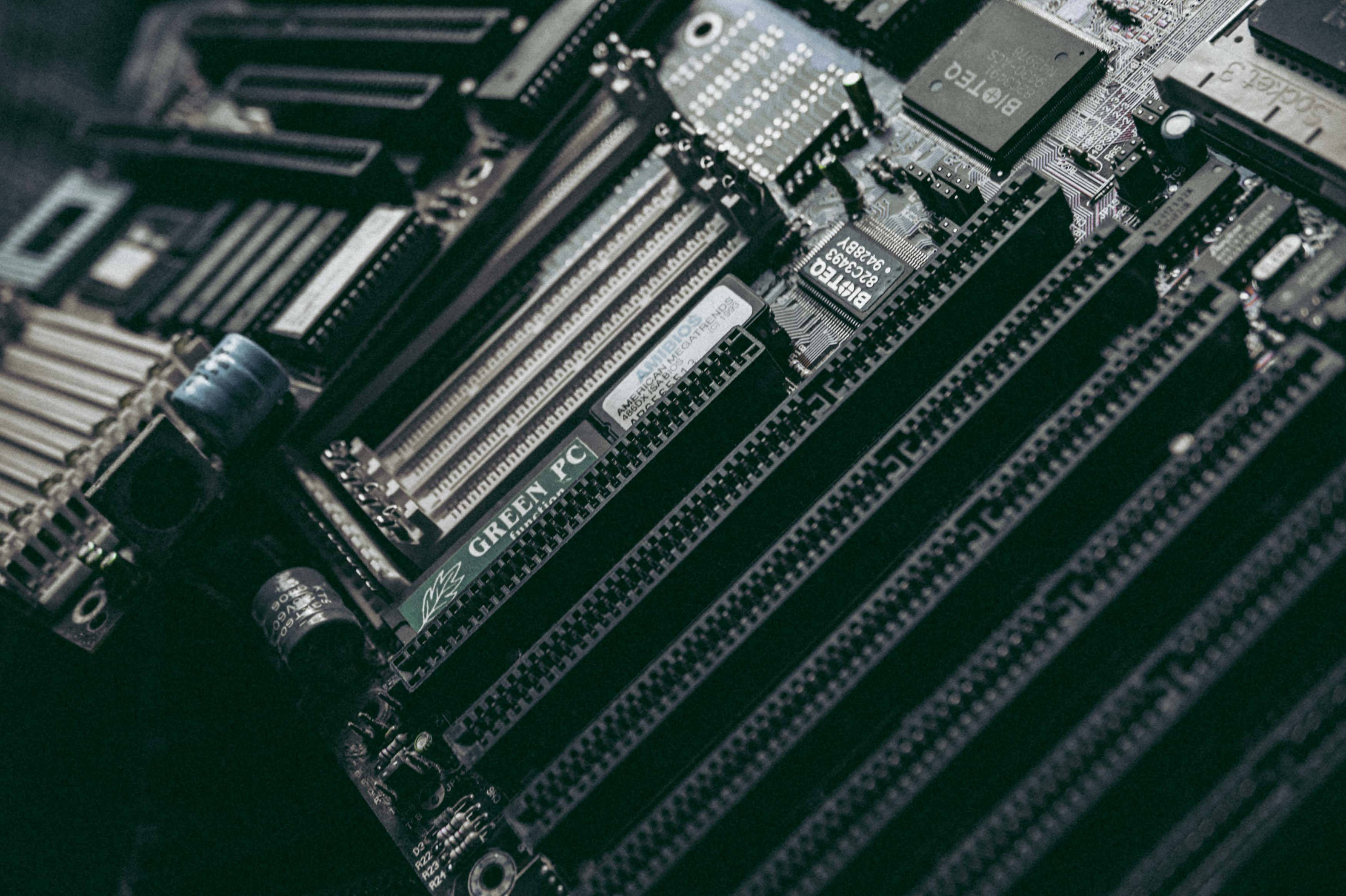 Motherboard 桌布 壁紙 — 電腦主機板特寫，具有 RAM 插槽和組件，在戲劇性的暗光下。