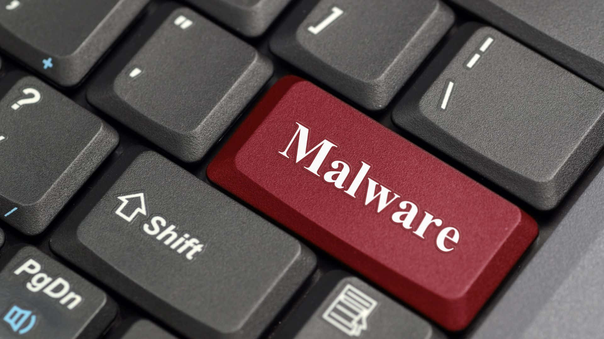 筆電 桌布 壁紙 — 電腦鍵盤的特寫，一個標有「Malware」的紅色按鍵在灰色按鍵中格外突出。