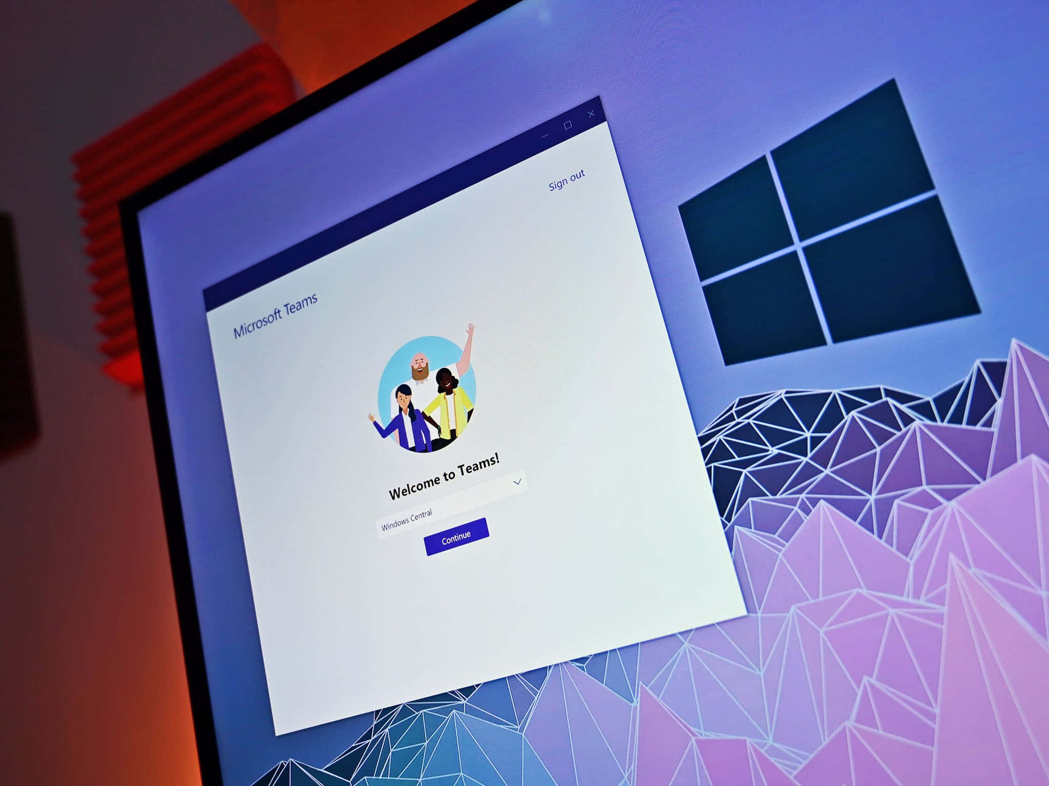 Microsoft Teams 桌布 壁紙 — 電腦顯示器在充滿活力的紫色幾何桌布上顯示Microsoft Teams歡迎畫面。