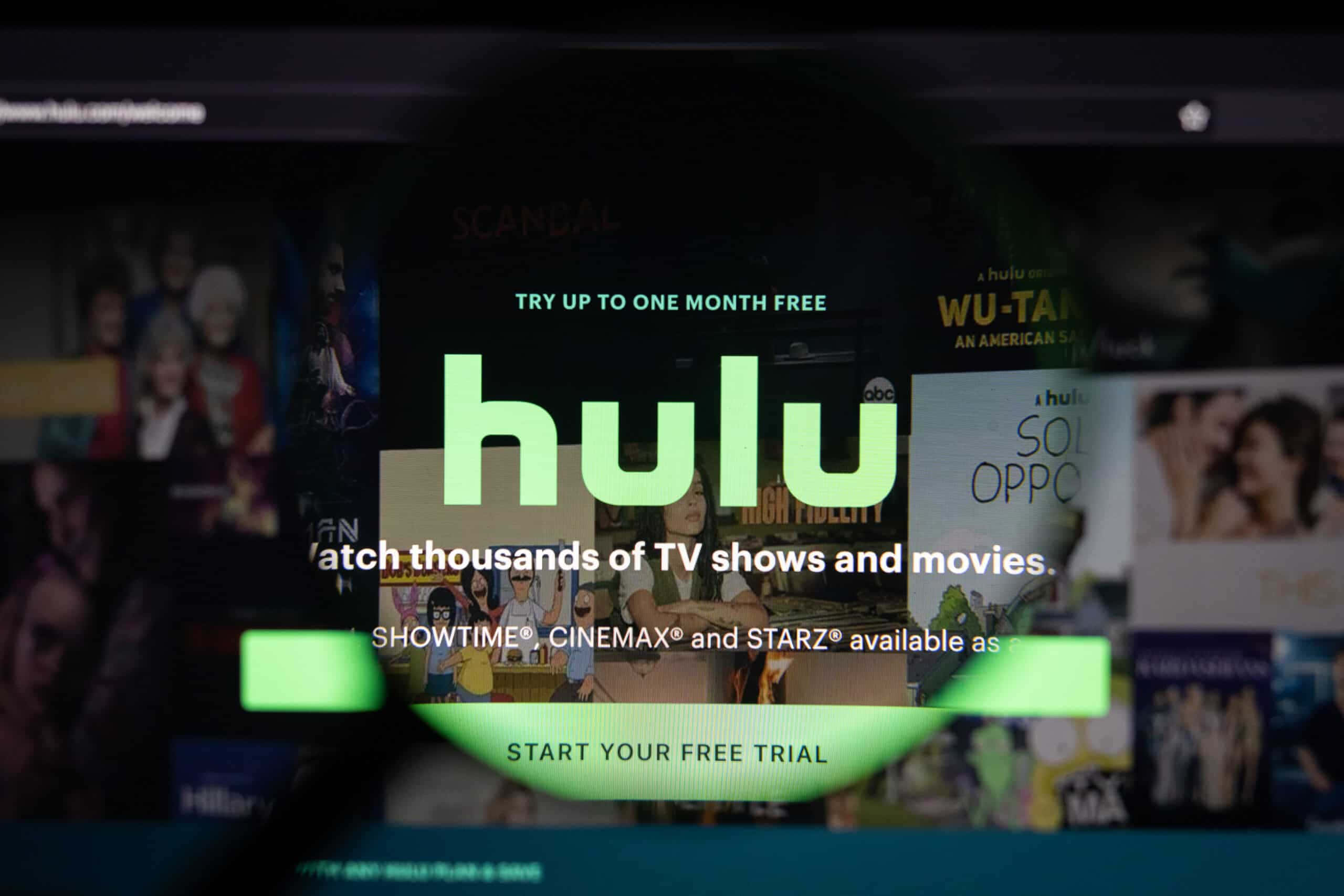 Hulu 桌布 壁紙 — 電視螢幕特寫，顯示Hulu串流服務首頁，帶有發光綠色文字和模糊的節目縮圖。
