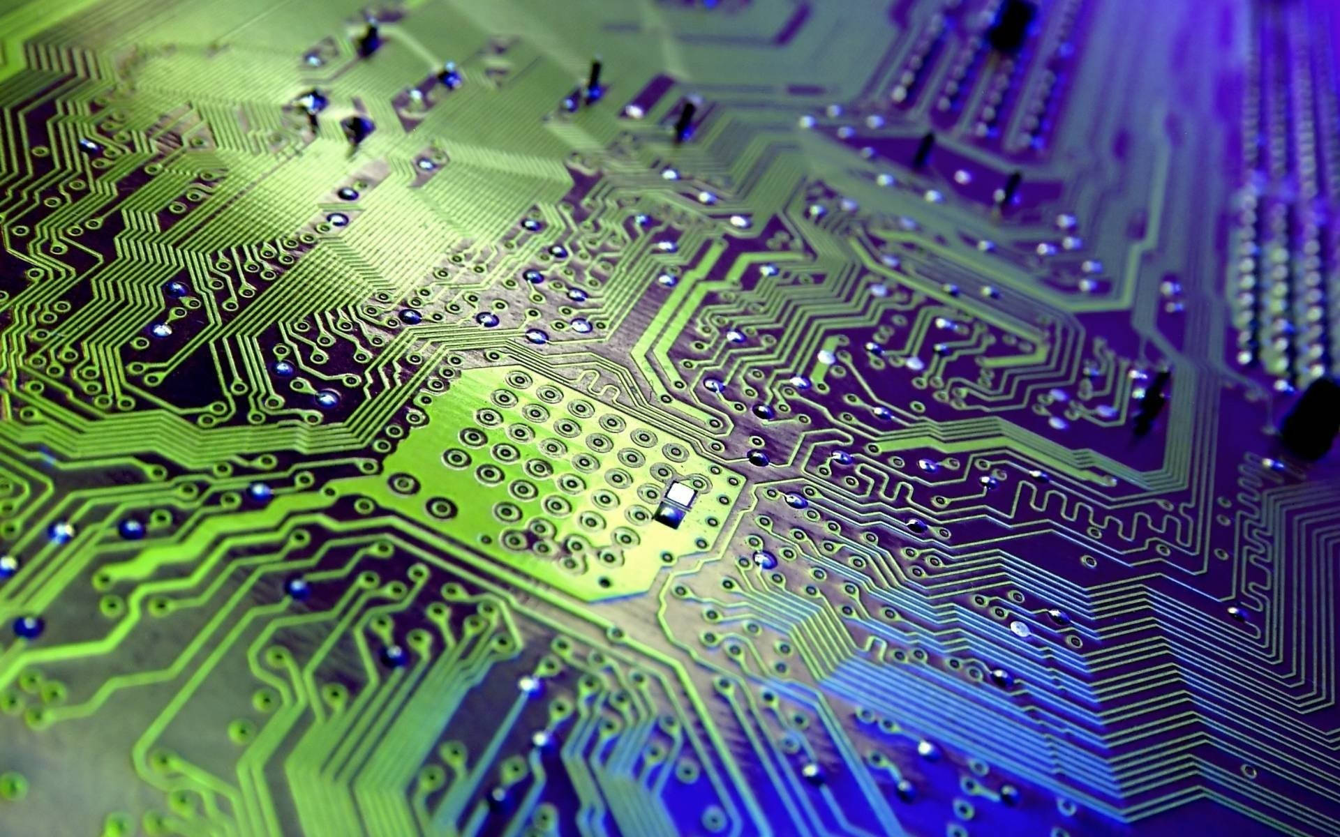 Processor 桌布 壁紙 — 電路板的特寫微距鏡頭，發出螢光綠和紫色光，揭示複雜的路徑和焊錫組件。