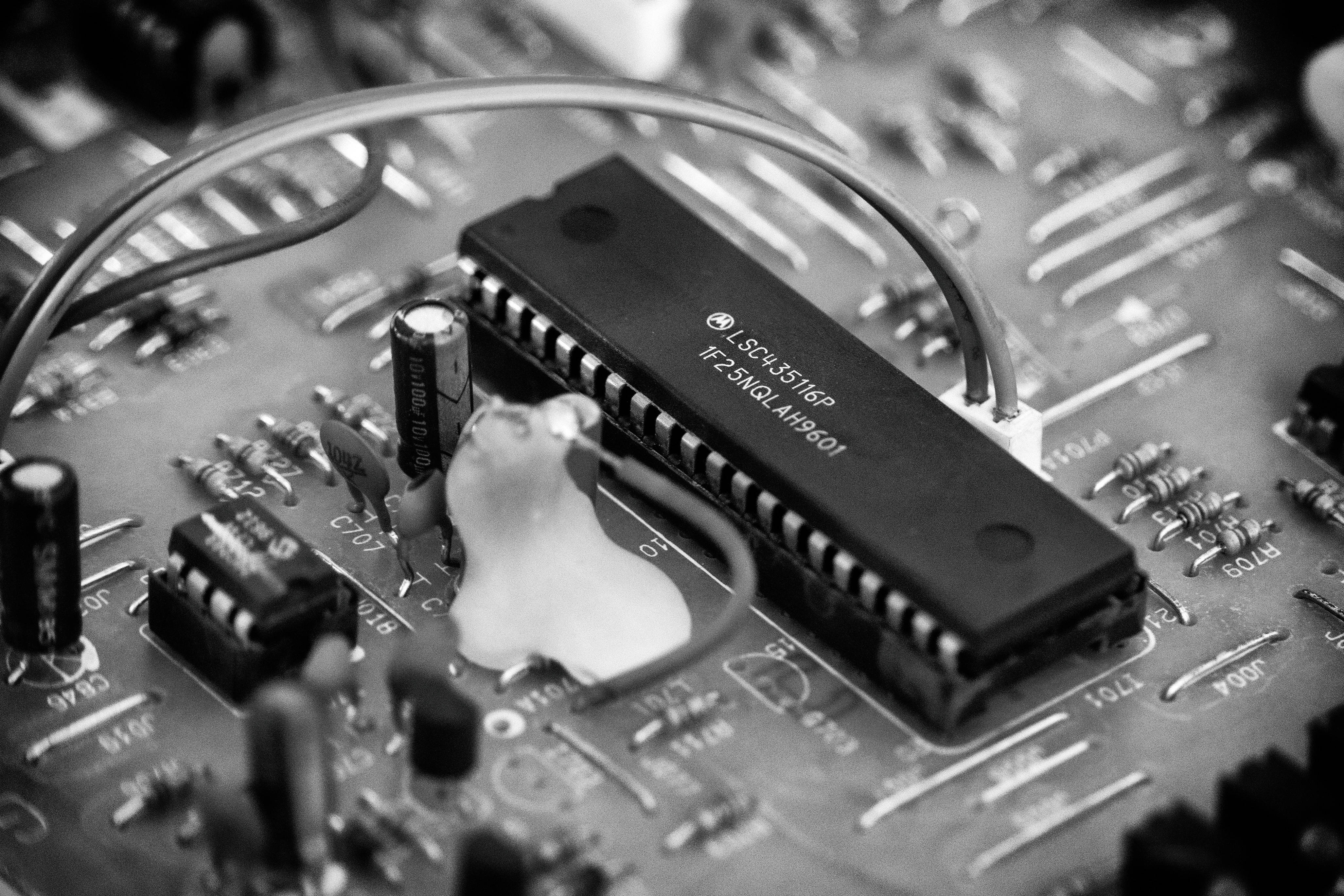 Motherboard 桌布 壁紙 — 電路板黑白特寫照片，中央有微型晶片和焊接線。