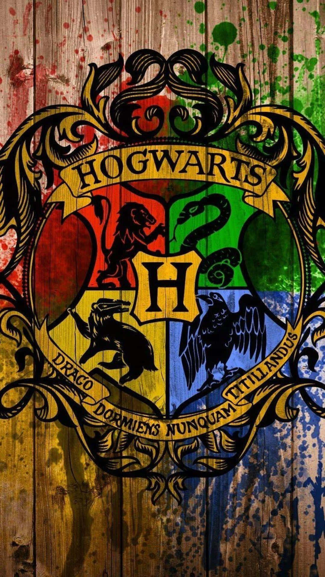 The Hogwarts Houses 桌布 壁紙 — 霍格華茲徽章以鮮豔色彩繪製在風化的木板上，帶有油漆飛濺。