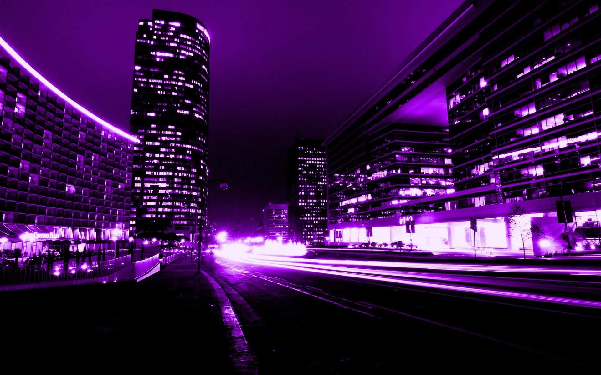 City At Night 桌布 壁紙 — 霓虹紫色夜間城市景觀，高聳現代建築之間有移動車輛的光軌。