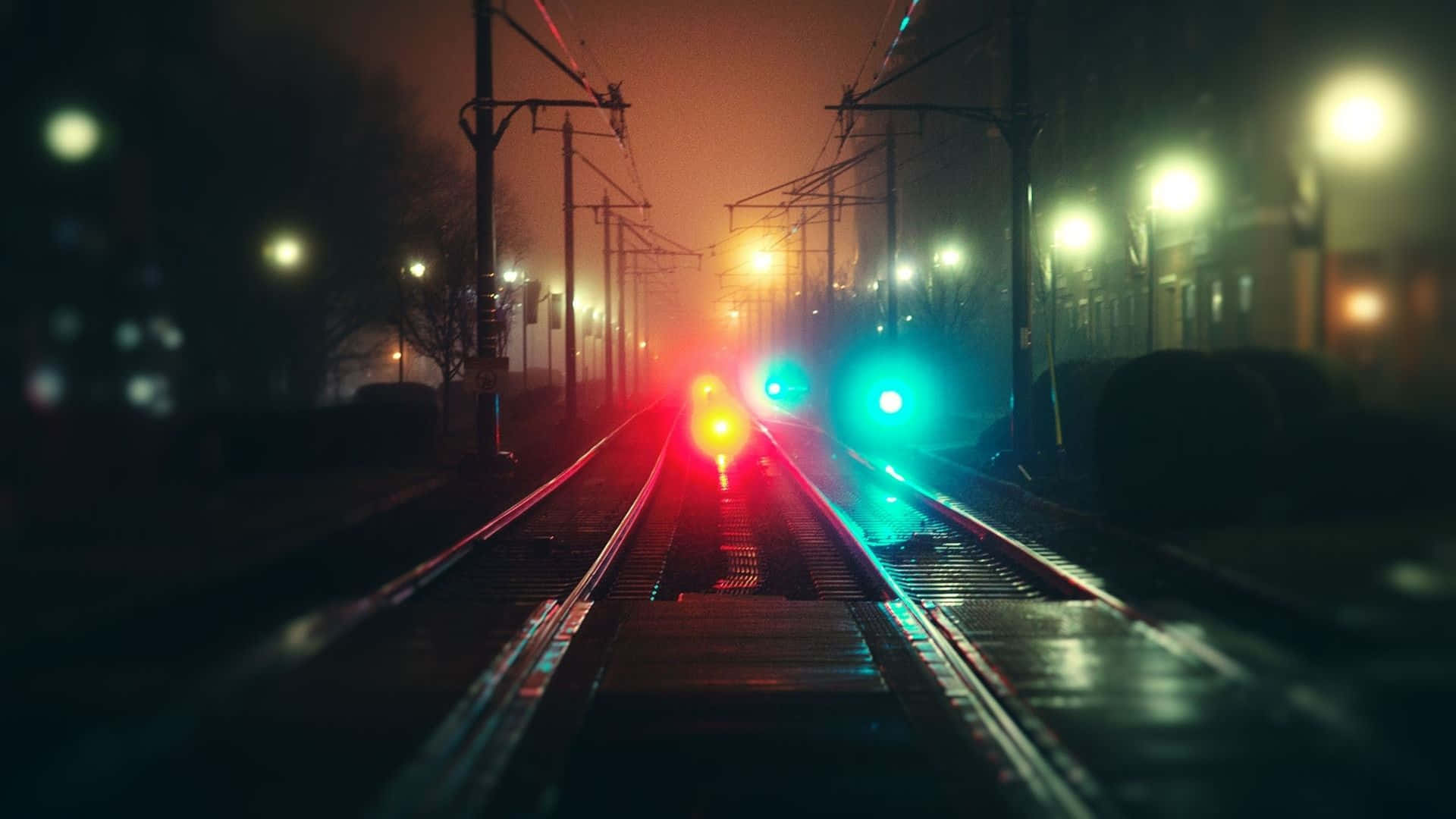 Chill 桌布 壁紙 — 霧夜鐵軌在溫暖街燈下匯聚向發光的紅綠火車信號燈。