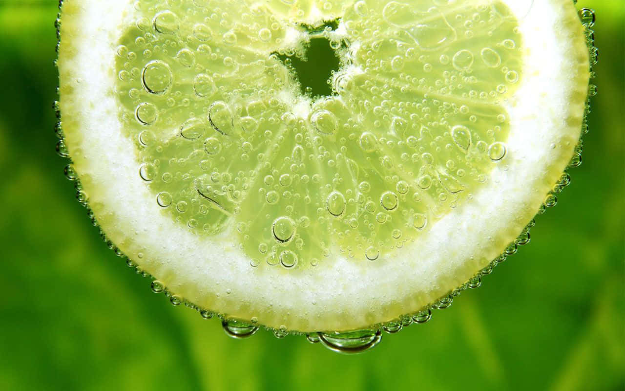 Lime 桌布 壁紙 — 青檸片浸在氣泡水中的特寫，氣泡附著在多汁的果肉上。