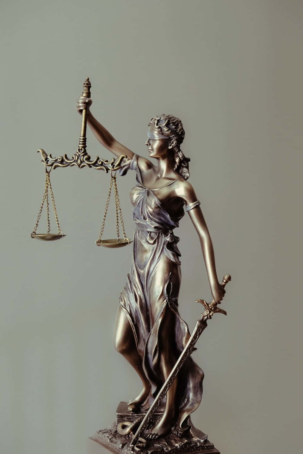 Court 桌布 壁紙 — 青銅正義女神雕像，手持天秤和劍，背景為純灰色。