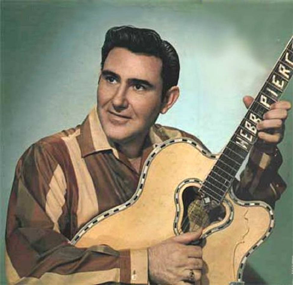 音樂 桌布 壁紙 — 音樂家 Webb Pierce 的復古肖像，他手持標誌性吉他，背景是柔和青綠色的錄音室。