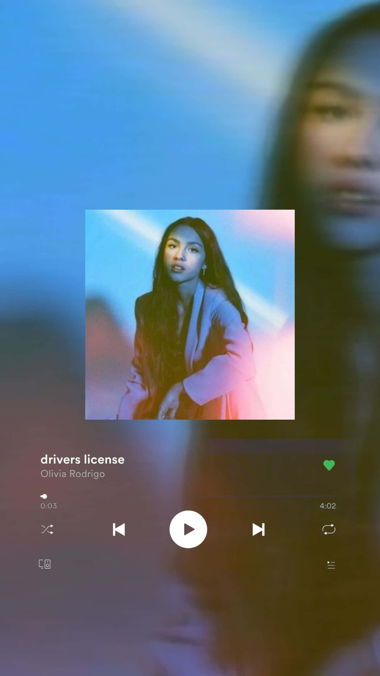 Olivia Rodrigo Aesthetic 桌布 壁紙 — 音樂播放器介面顯示 Olivia Rodrigo 的《drivers license》，背景為模糊的人像，並帶有鮮豔的藍色和粉紅色燈光。