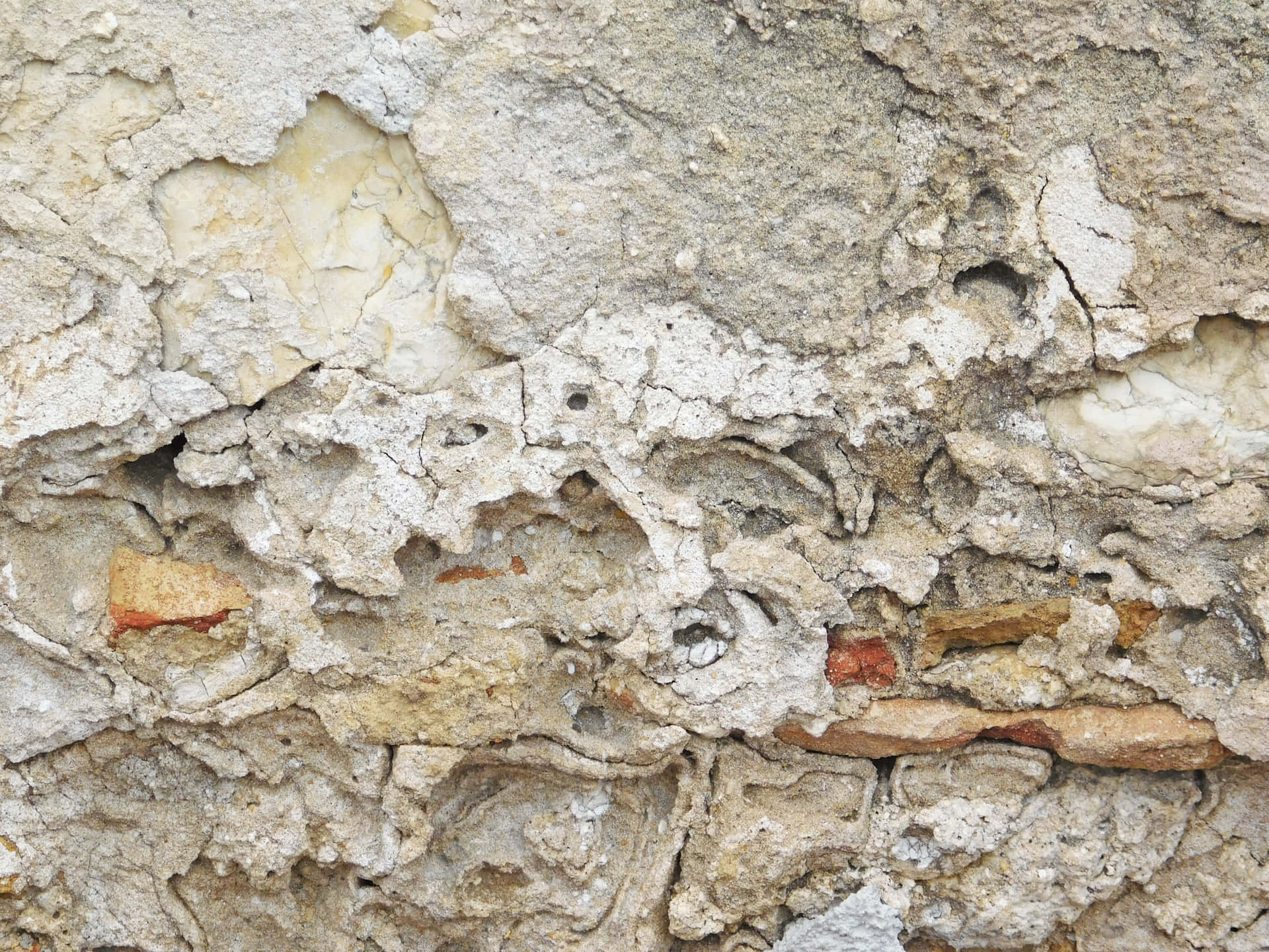 Stone texture 壁紙 — 風化混凝土牆的特寫，裂開剝落的油漆露出底下的磚塊和砂漿。