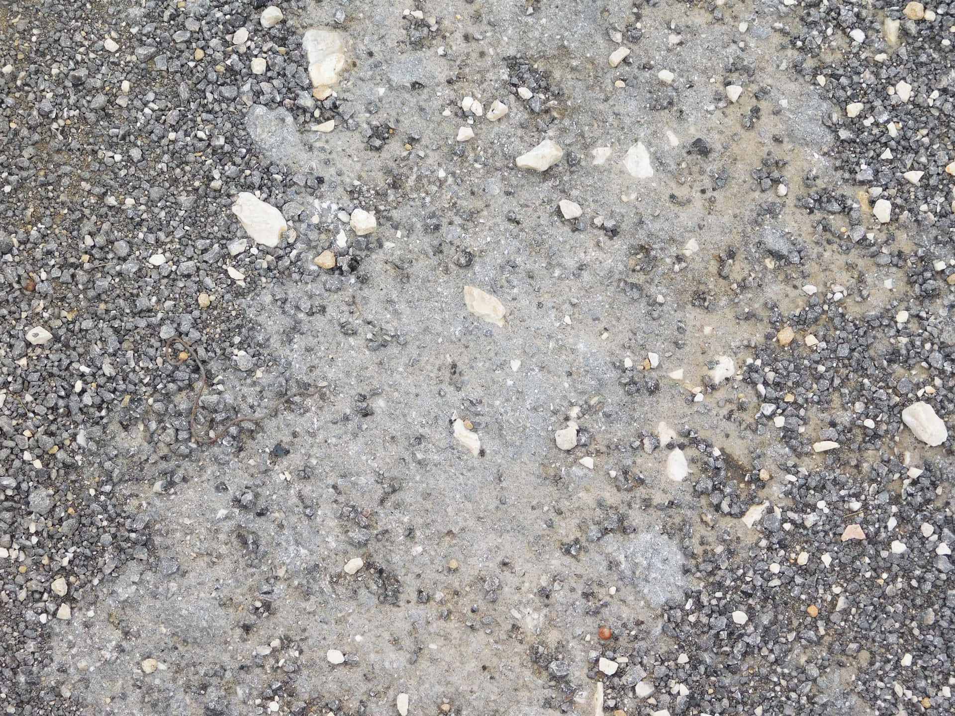 Stone texture 壁紙 — 風化瀝青路面的特寫，散落著灰色、白色和棕色的礫石。