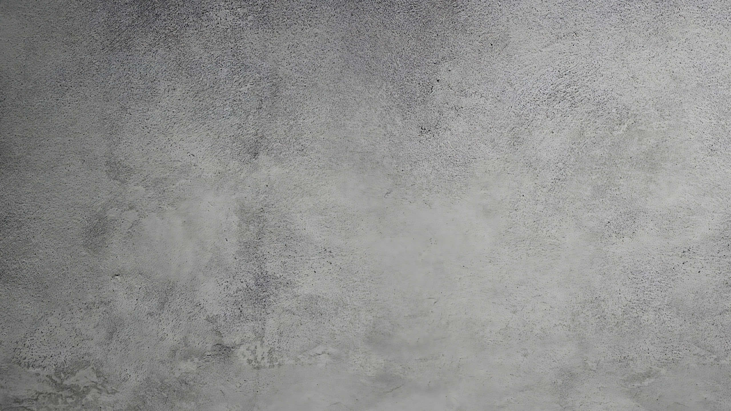 Grey Texture 桌布 壁紙 — 風化灰色混凝土牆的特寫，帶有細微紋理和斑點瑕疵。