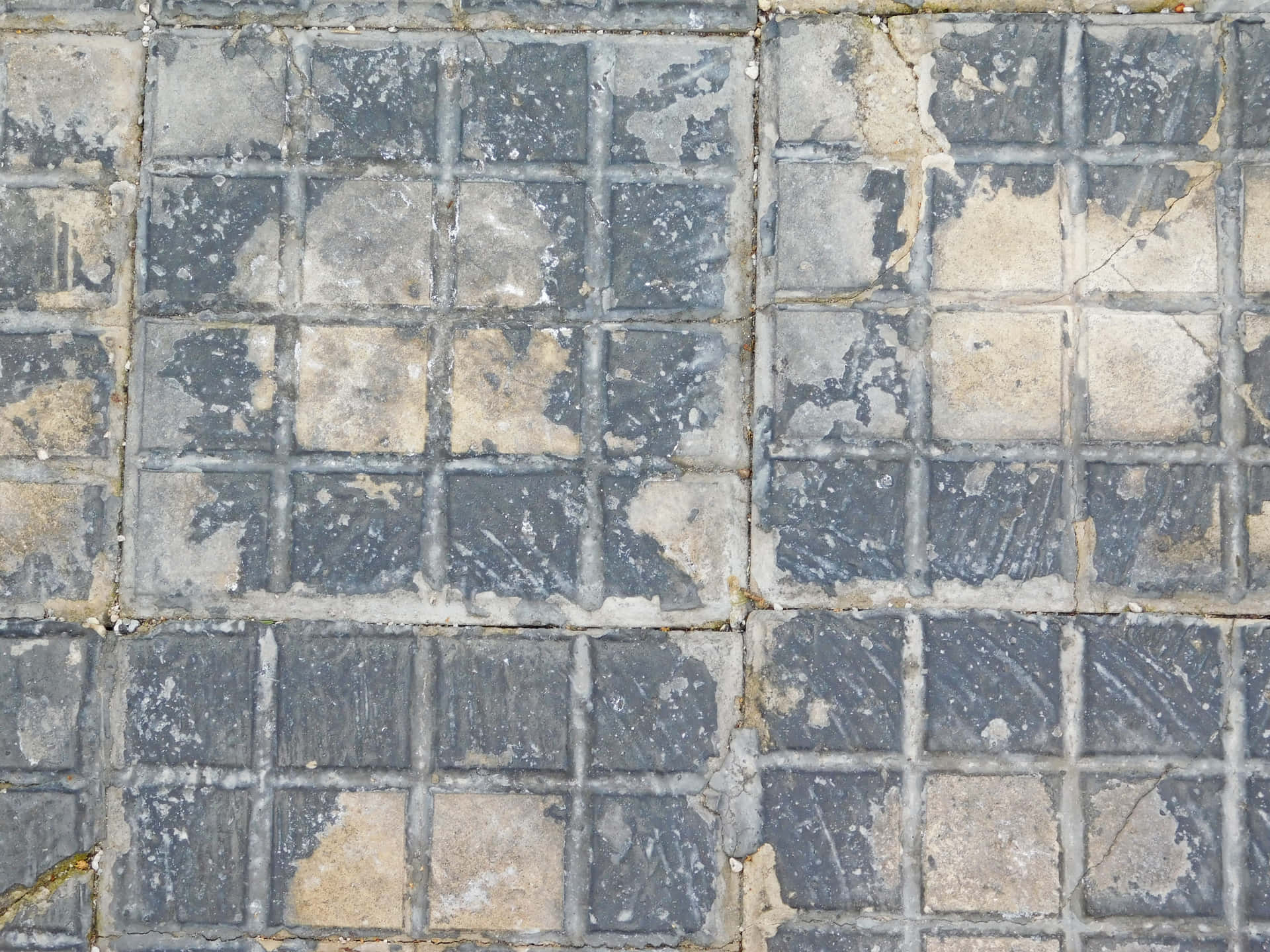 Stone texture 壁紙 — 風化灰色石磚的特寫，帶有裂縫的填縫劑和米色變色斑塊。
