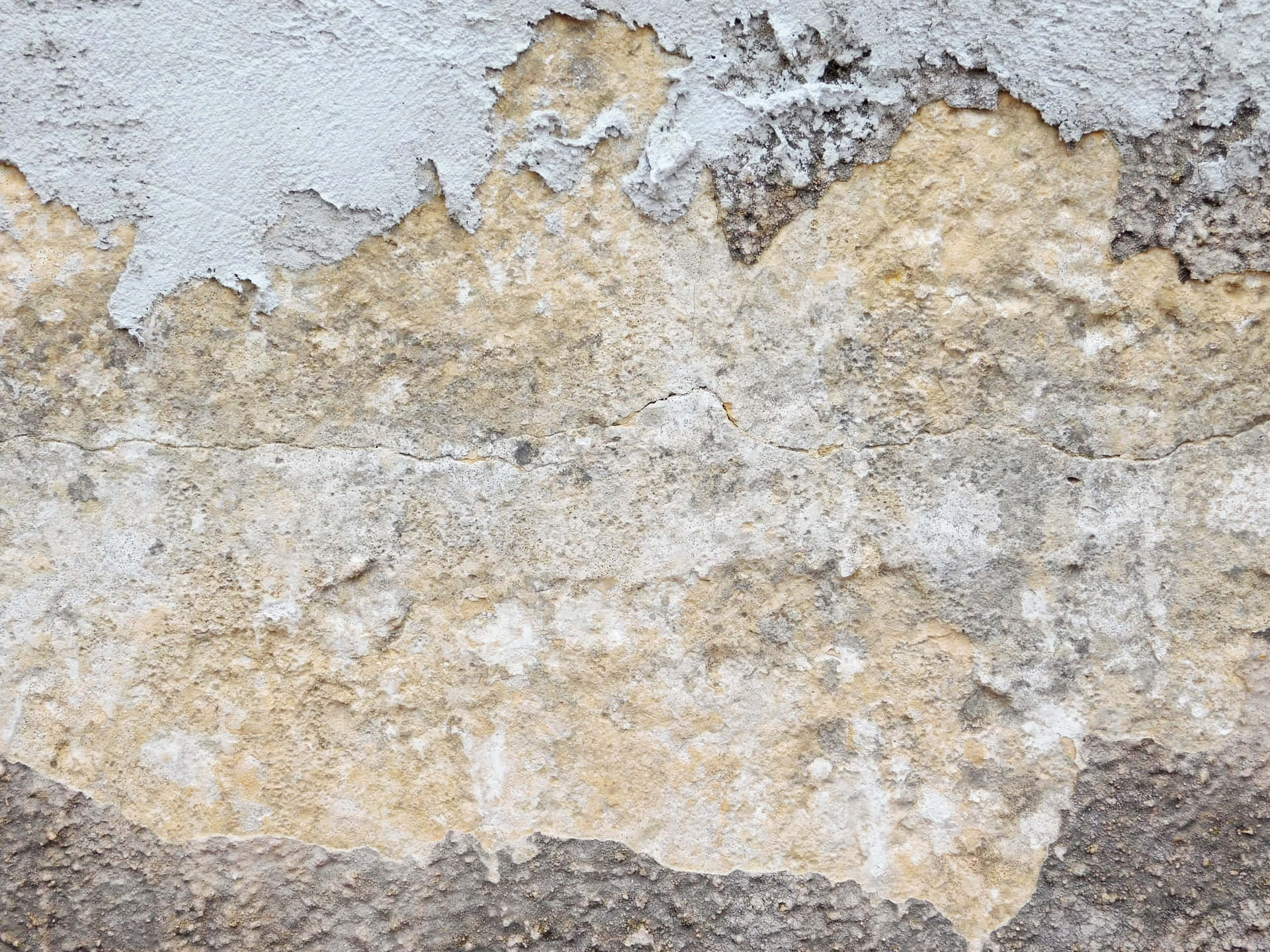 Stone texture 壁紙 — 風化牆壁的特寫，剝落的灰色油漆露出底下帶紋理的米色和灰色灰泥。
