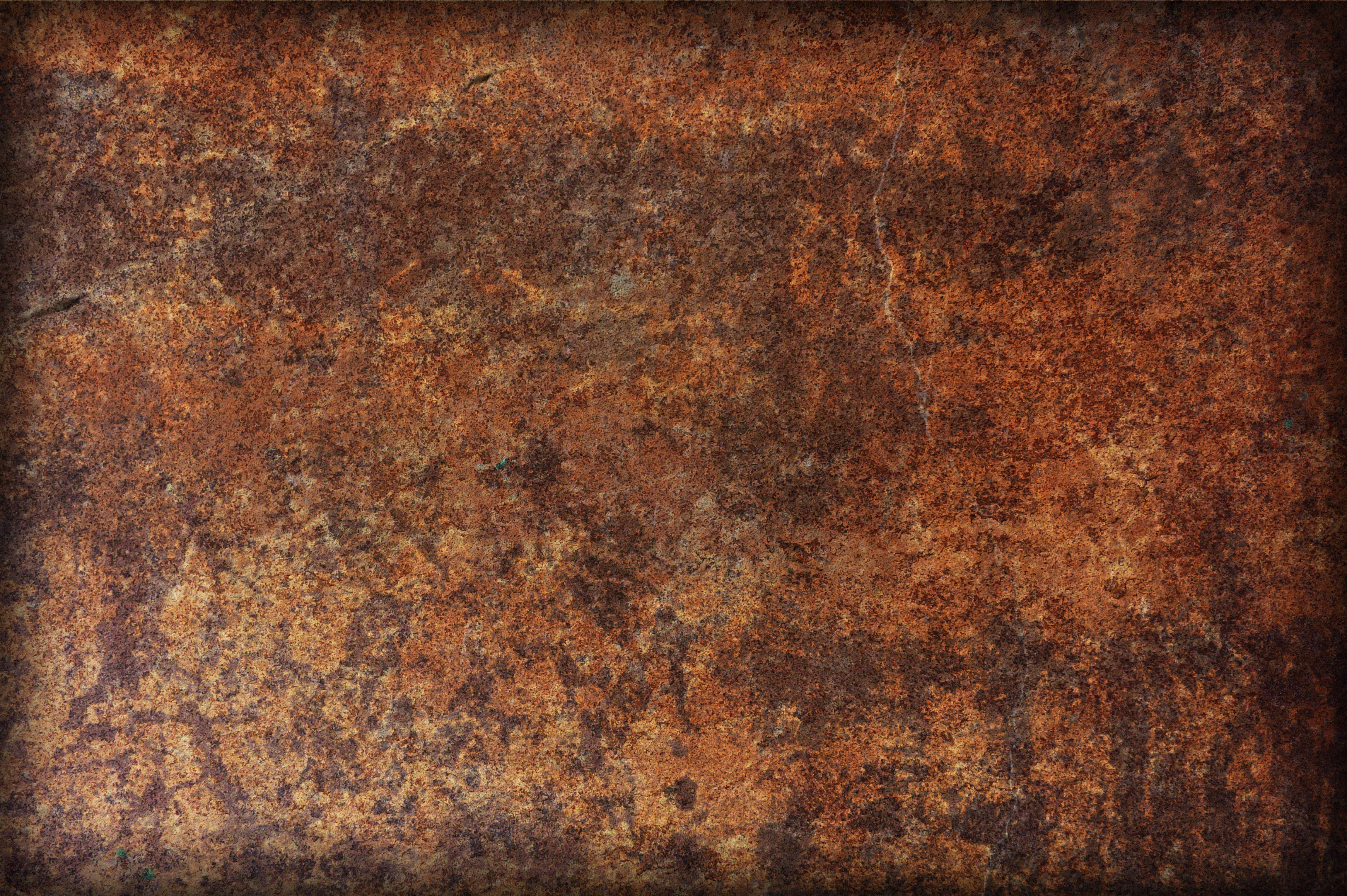 Rust 桌布 壁紙 — 風化生鏽金屬的特寫，帶有豐富的橙棕色紋理和深邃的陰影裂縫。