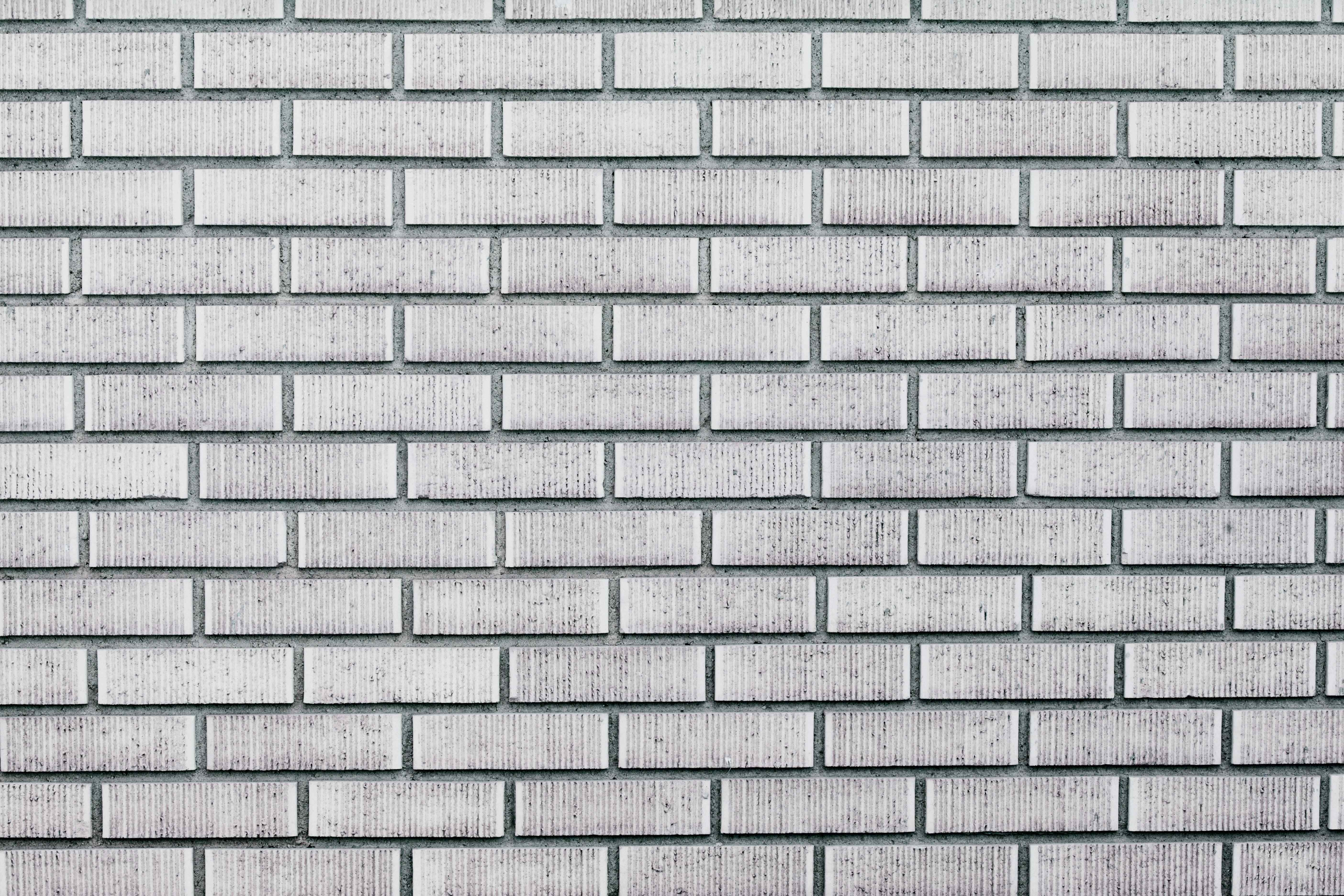White Brick Wall 桌布 壁紙 — 風化白色磚牆的特寫，帶有紋理灰泥線條和細微灰色斑點。