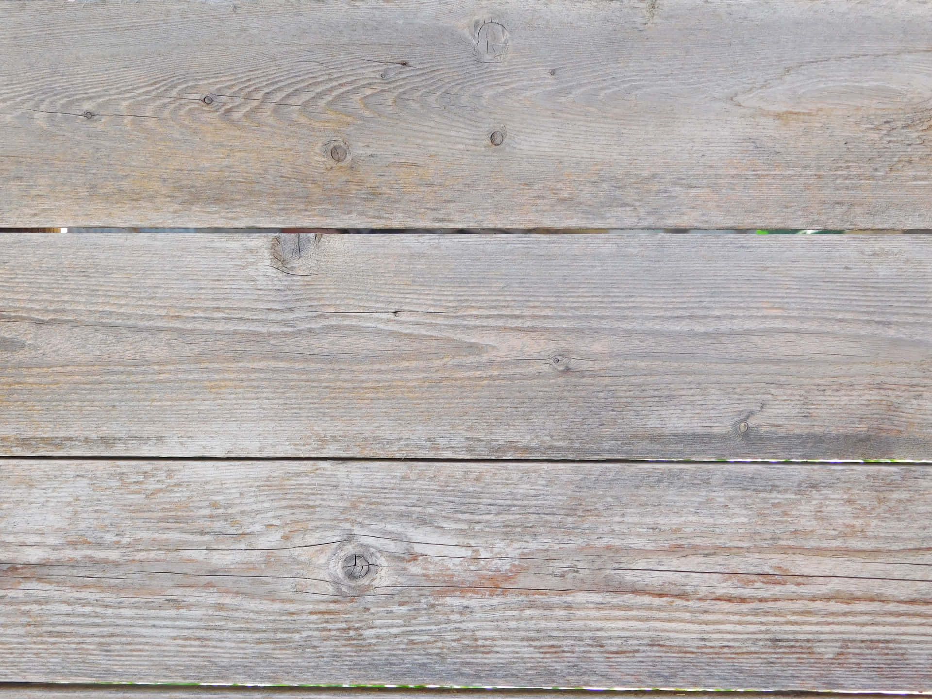 Wood texture 壁紙 — 風化的灰色木板，帶有可見的木紋和節疤，以及微妙的棕色污漬，形成質樸的紋理表面。
