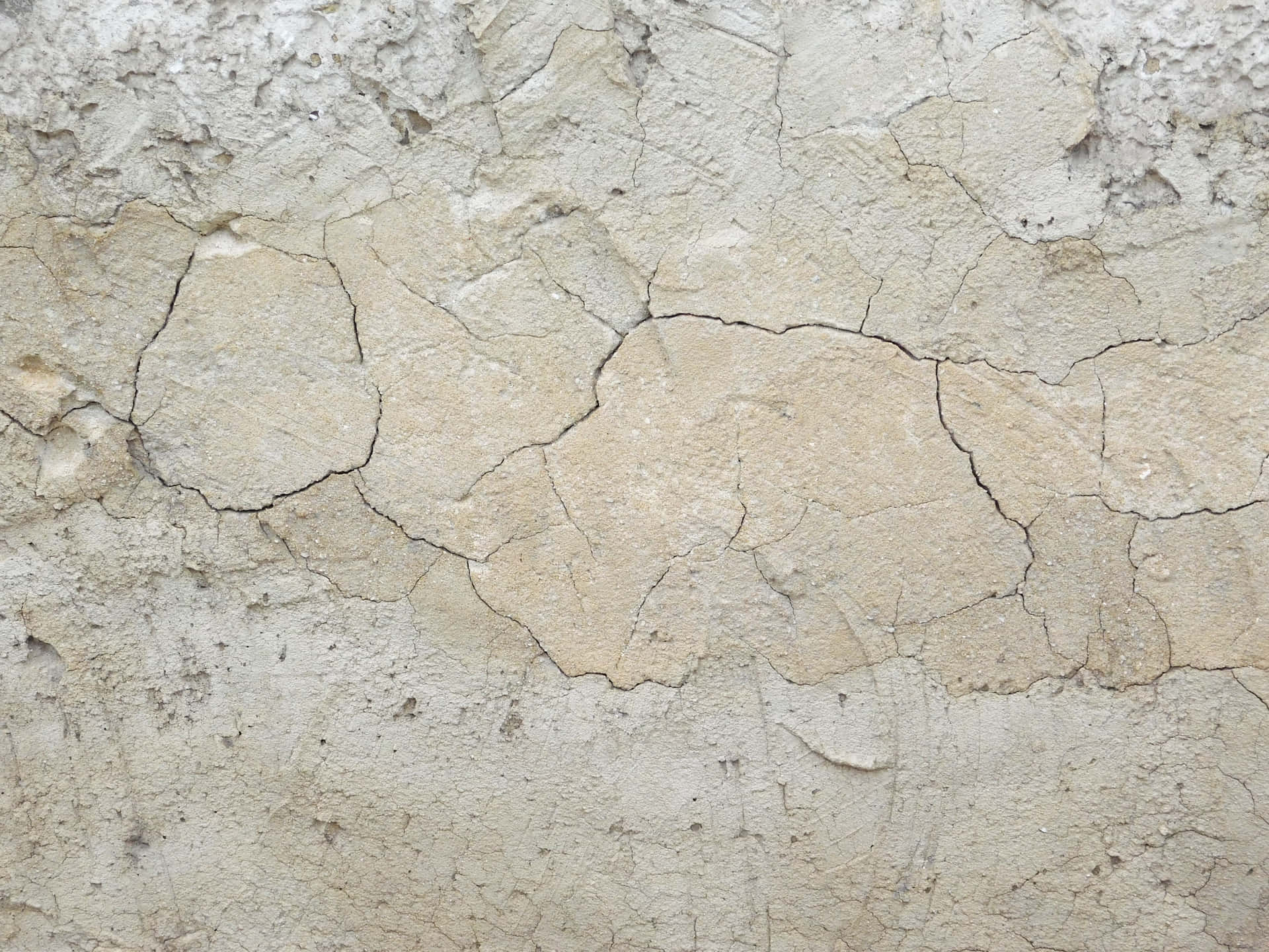 Stone texture 壁紙 — 風化的米色灰泥牆特寫，帶有深裂紋和粗糙質感。