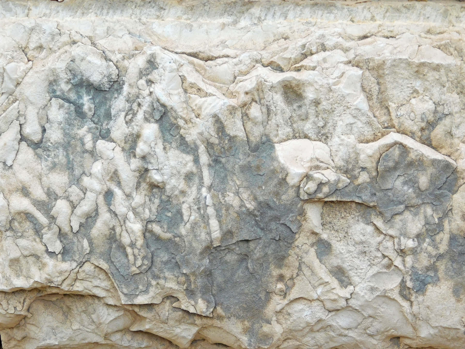 Stone texture 壁紙 — 風化石牆的特寫，呈現米色、灰色和白色的層次紋理，顯示自然侵蝕圖案。