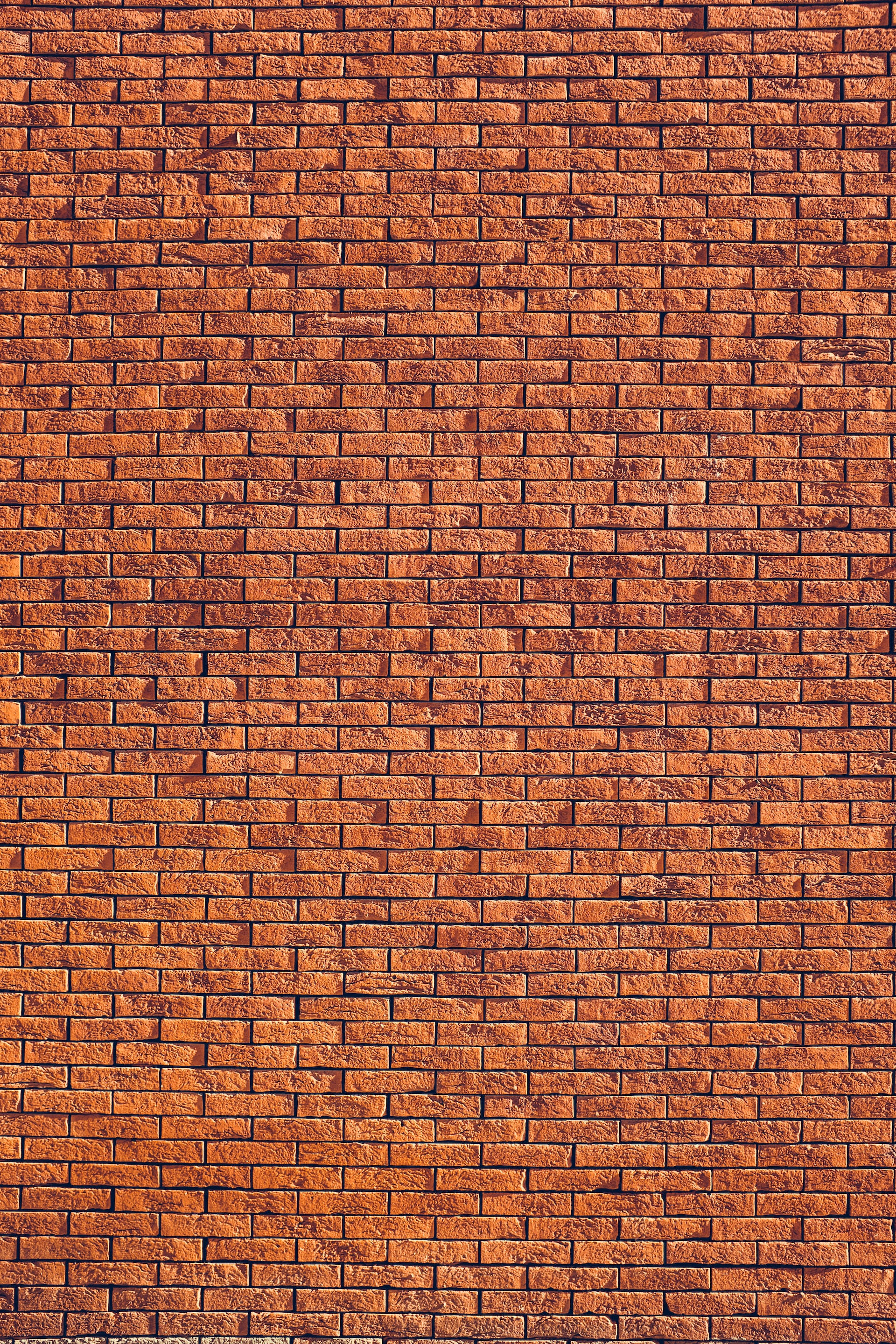 Brick Wall 桌布 壁紙 — 風化紅磚牆的特寫，帶有紋理灰泥線條和溫暖的大地色調。