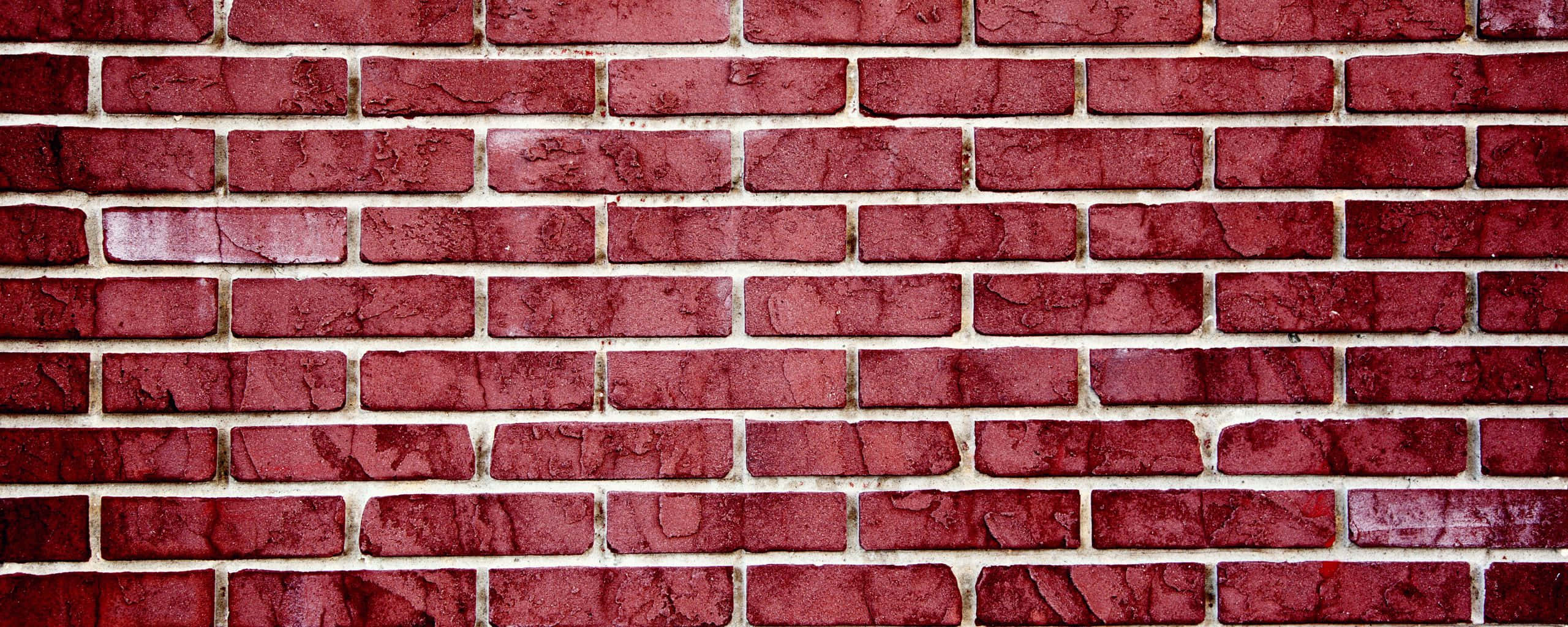 Brick Wall 桌布 壁紙 — 風化紅磚牆的特寫，帶有紋理灰泥線條和細微的色彩變化。