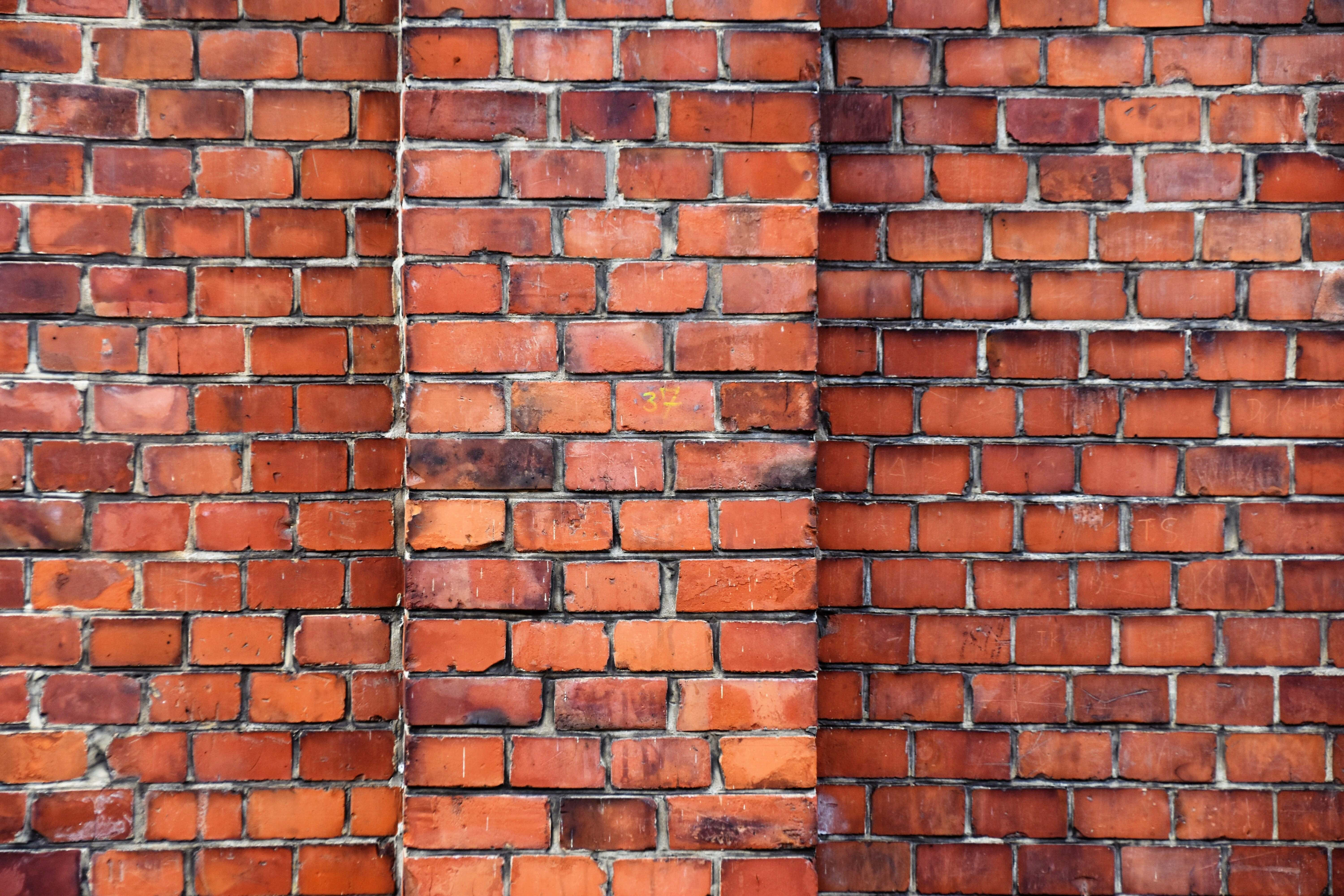 Brick Wall 桌布 壁紙 — 風化紅磚牆的近距離特寫，可見砂漿線條和微妙的顏色變化。