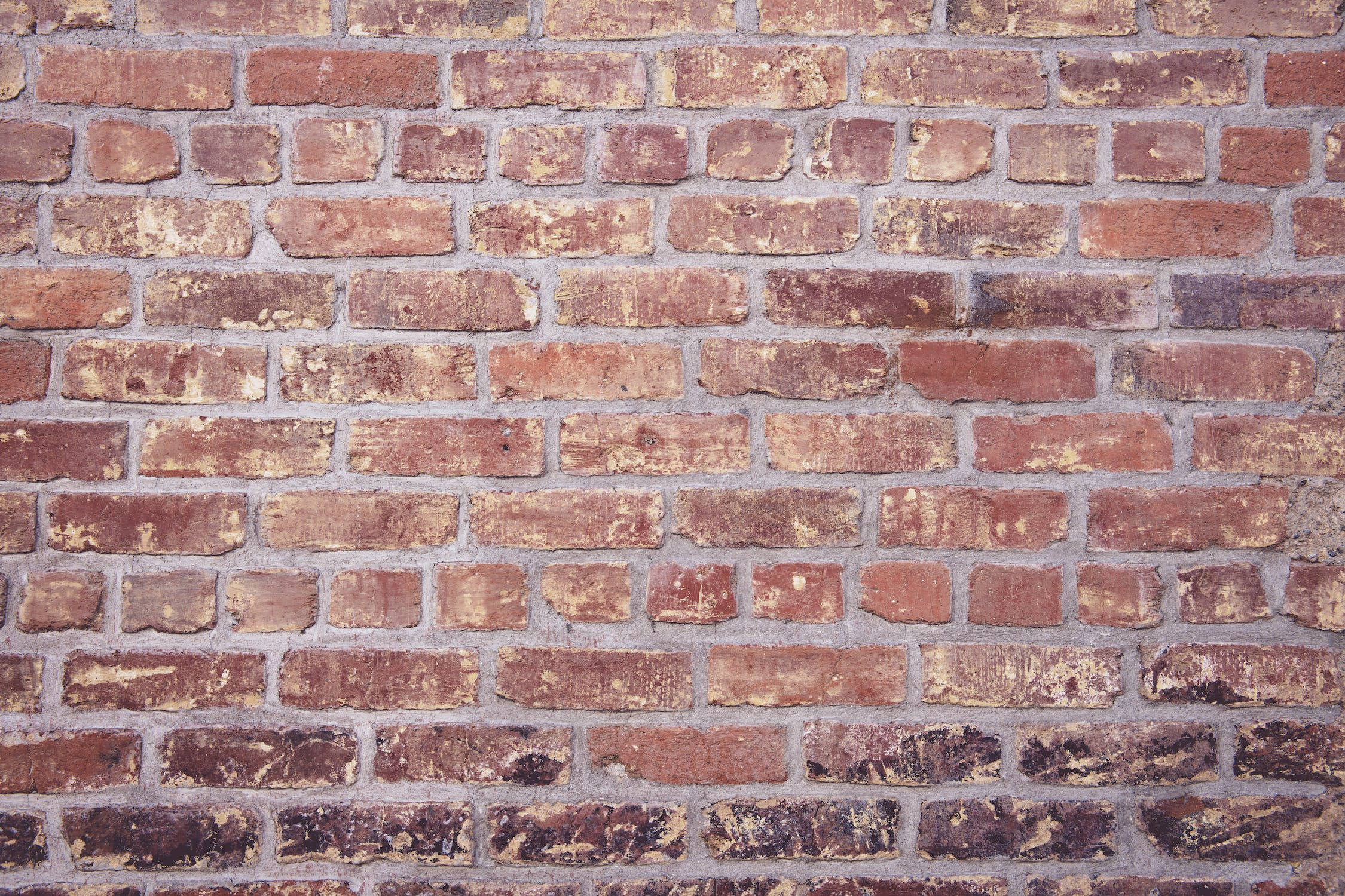 Brick Wall 桌布 壁紙 — 風化紅磚牆近距離特寫，帶灰色砂漿和質樸紋理。