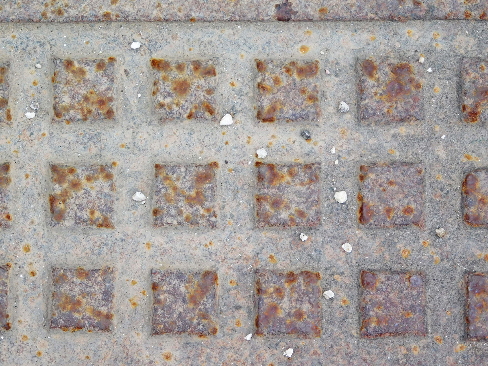 Metal texture 壁紙 — 風化金屬格柵的特寫，帶有生鏽的方形板和灰色表面上散落的白色碎屑。