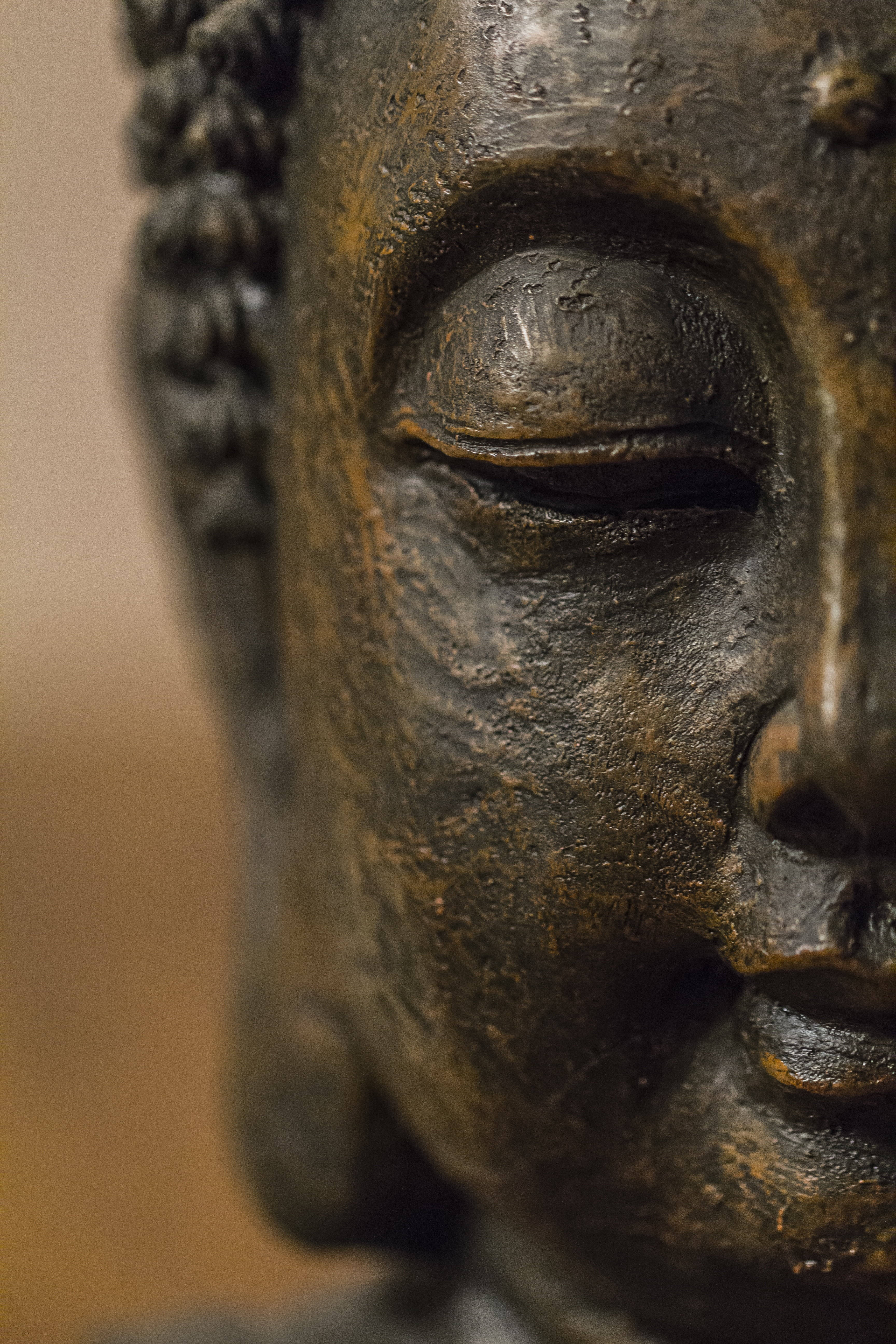 black buddha 桌布 壁紙 — 風化青銅佛像特寫，雙眼平靜閉合，表面紋理清晰。