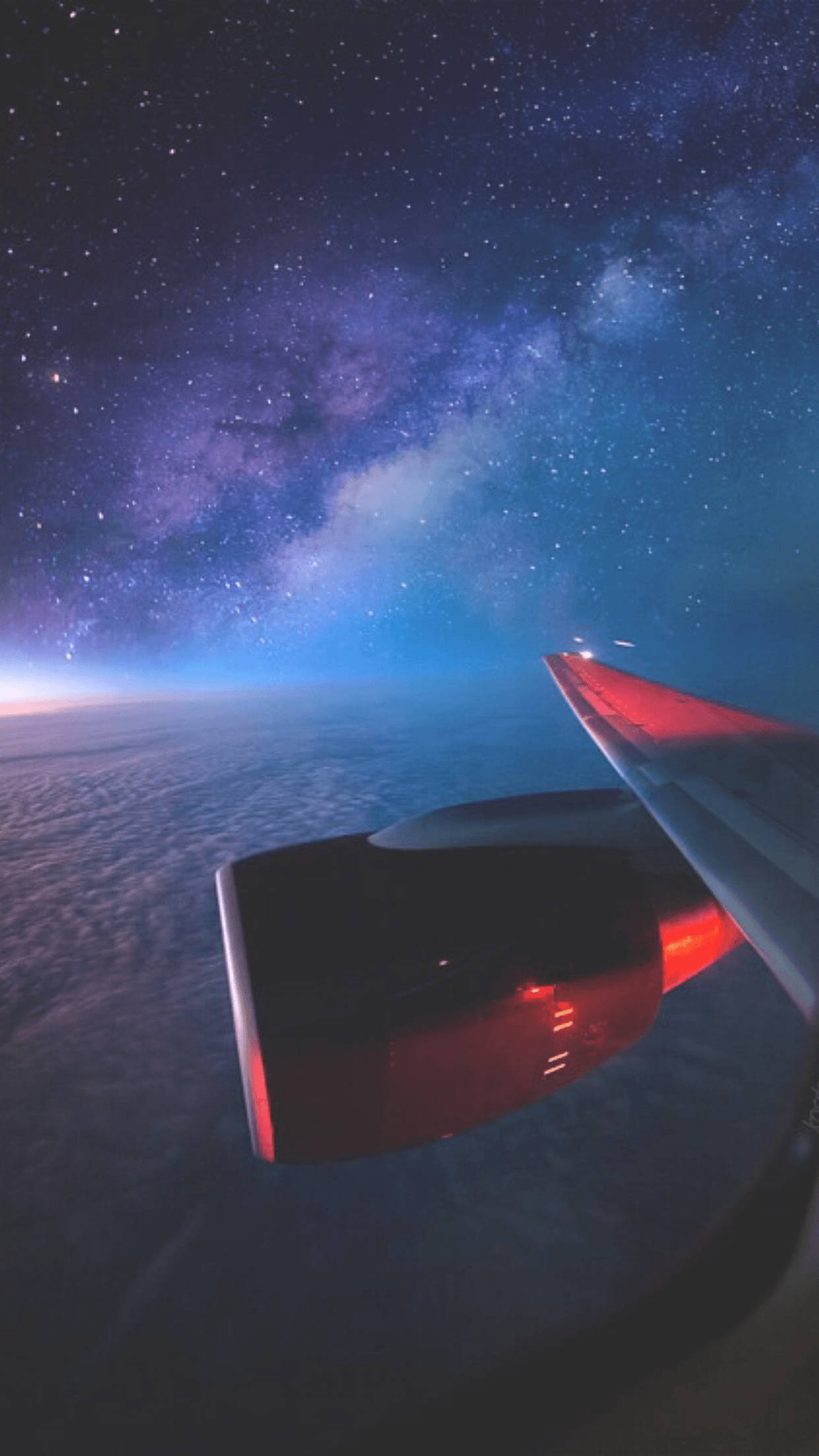 飛機 桌布 壁紙 — 飛機翼在繁星點點的夜空中發出紅光，上方有銀河，下方有雲層。