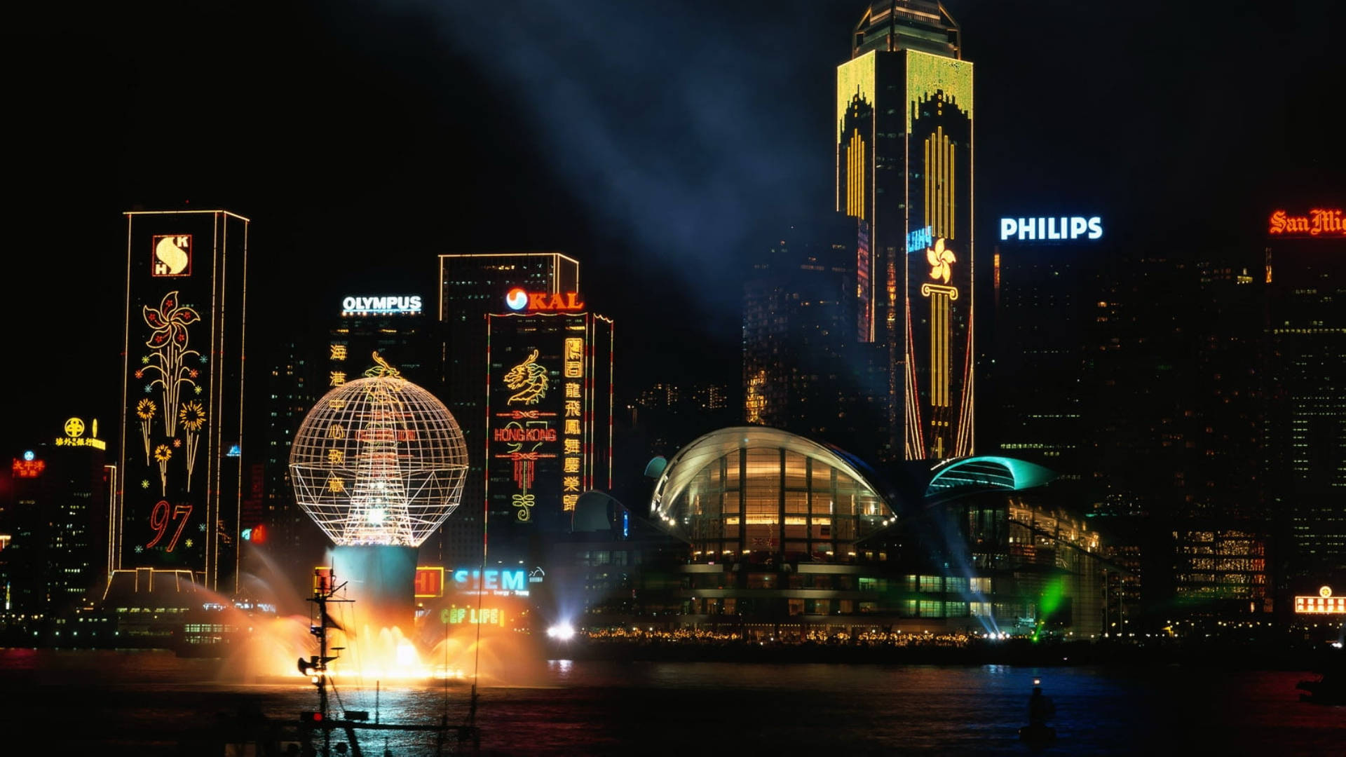 X 桌布 壁紙 — 香港令人驚嘆的夜景，有燈火通明的摩天大樓和在水面上反射的發光地球雕塑。