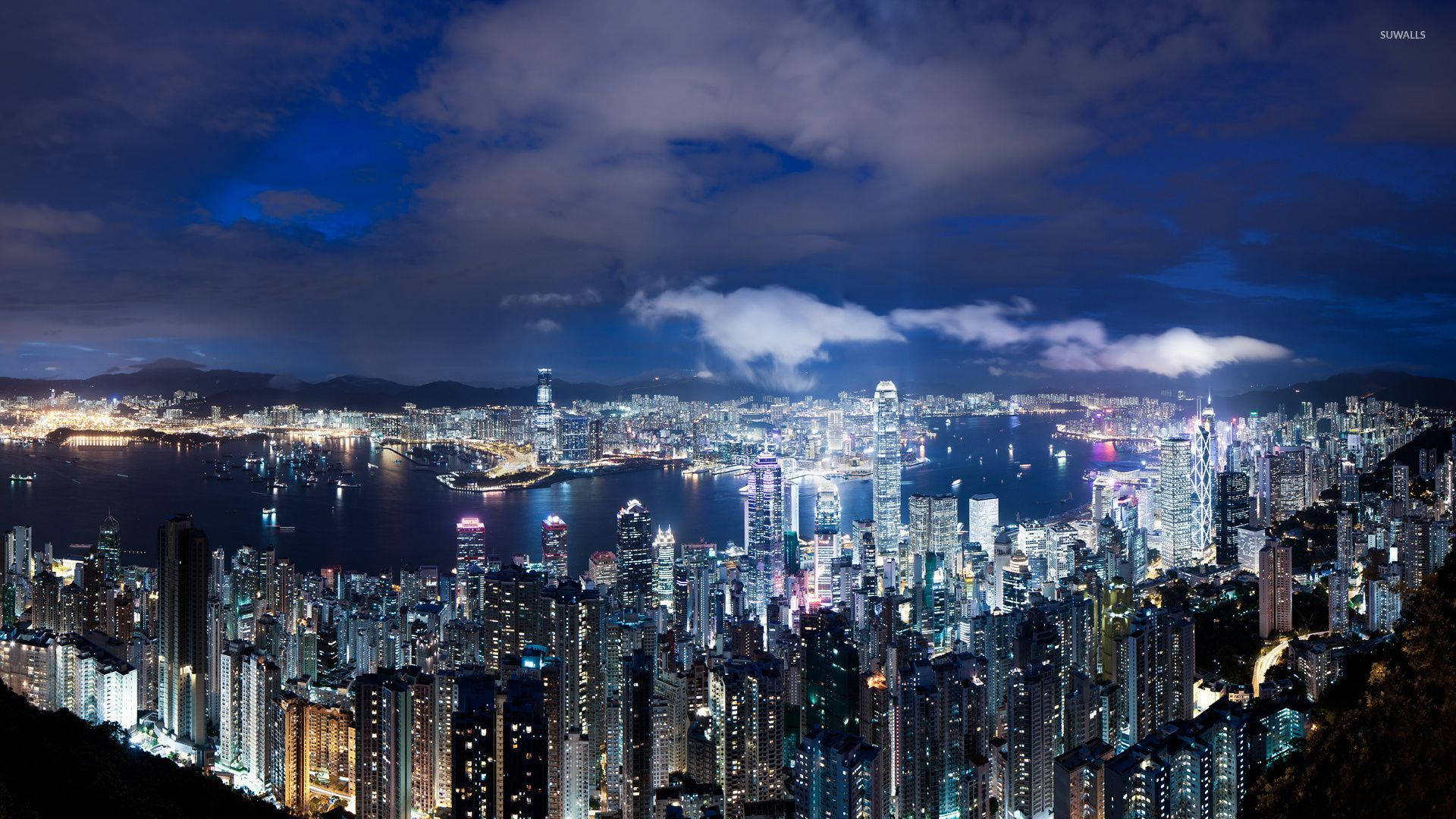 Ho Chi Minh City 桌布 壁紙 — 香港令人驚嘆的夜景，閃爍的摩天大樓和港口在戲劇性的多雲天空下。