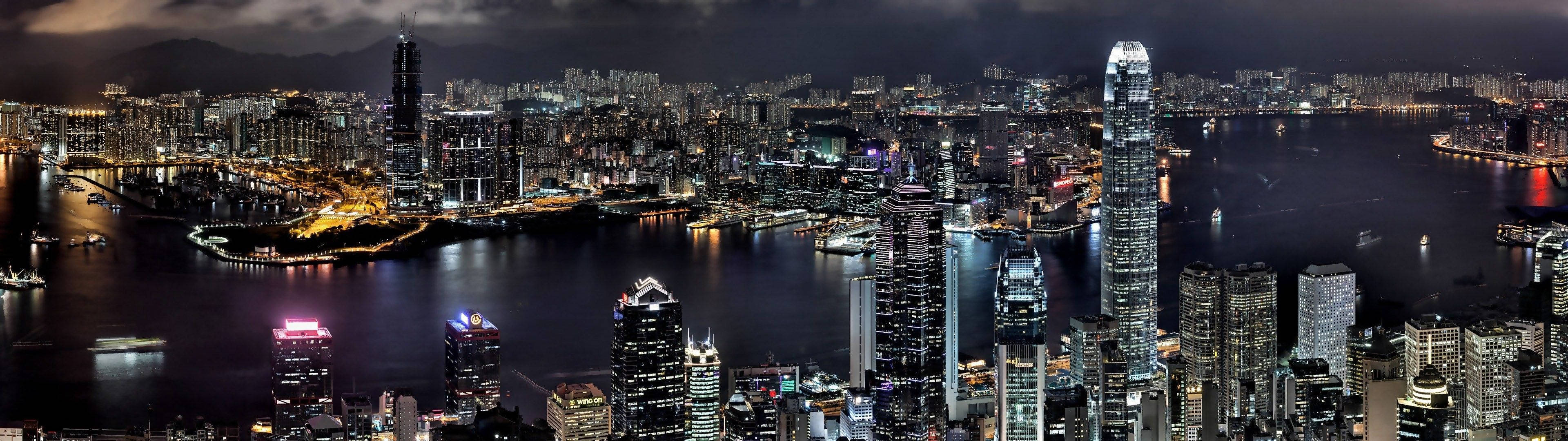Dual 桌布 壁紙 — 香港天際線的 panoramic 夜景，閃爍的摩天大樓和充滿船隻的活力海港。