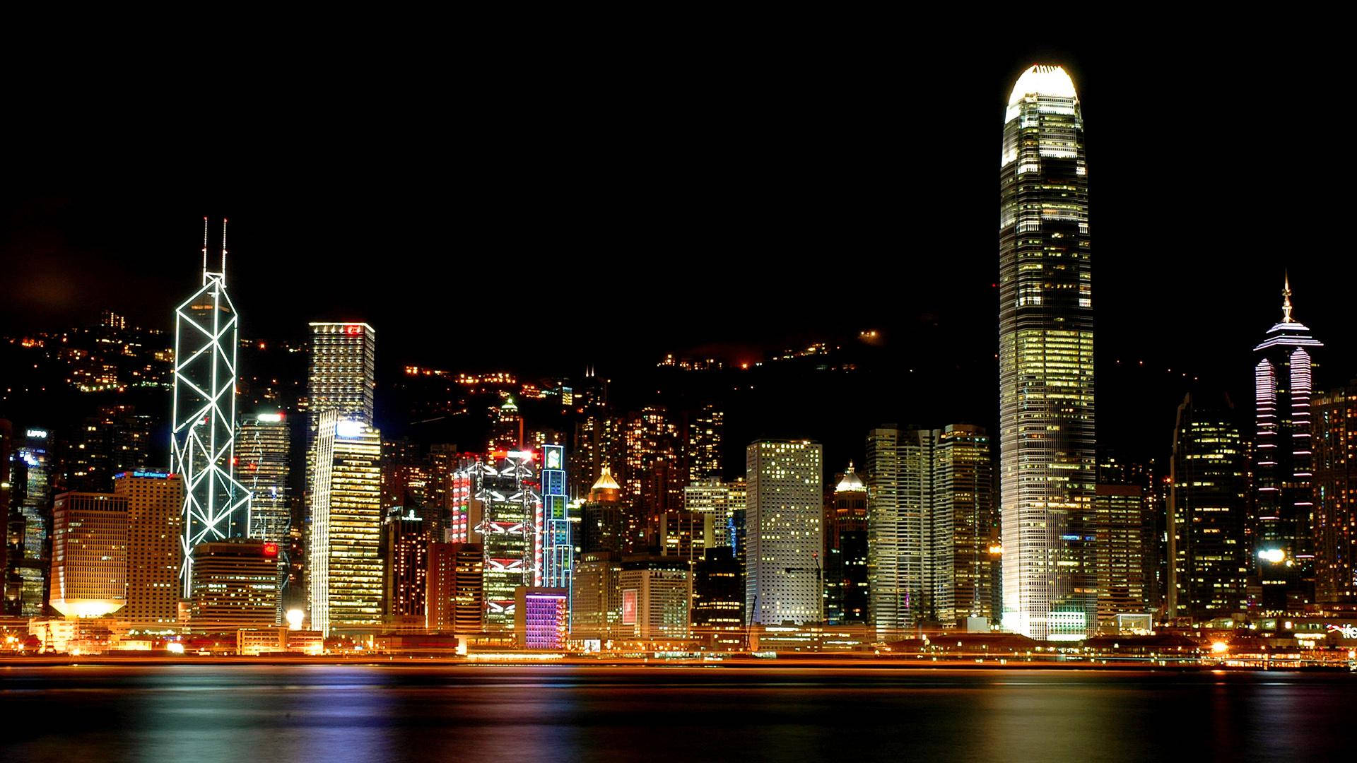 Montreal 桌布 壁紙 — 香港天際線的迷人夜景，燈火通明的摩天大樓倒映在平靜的水面上。