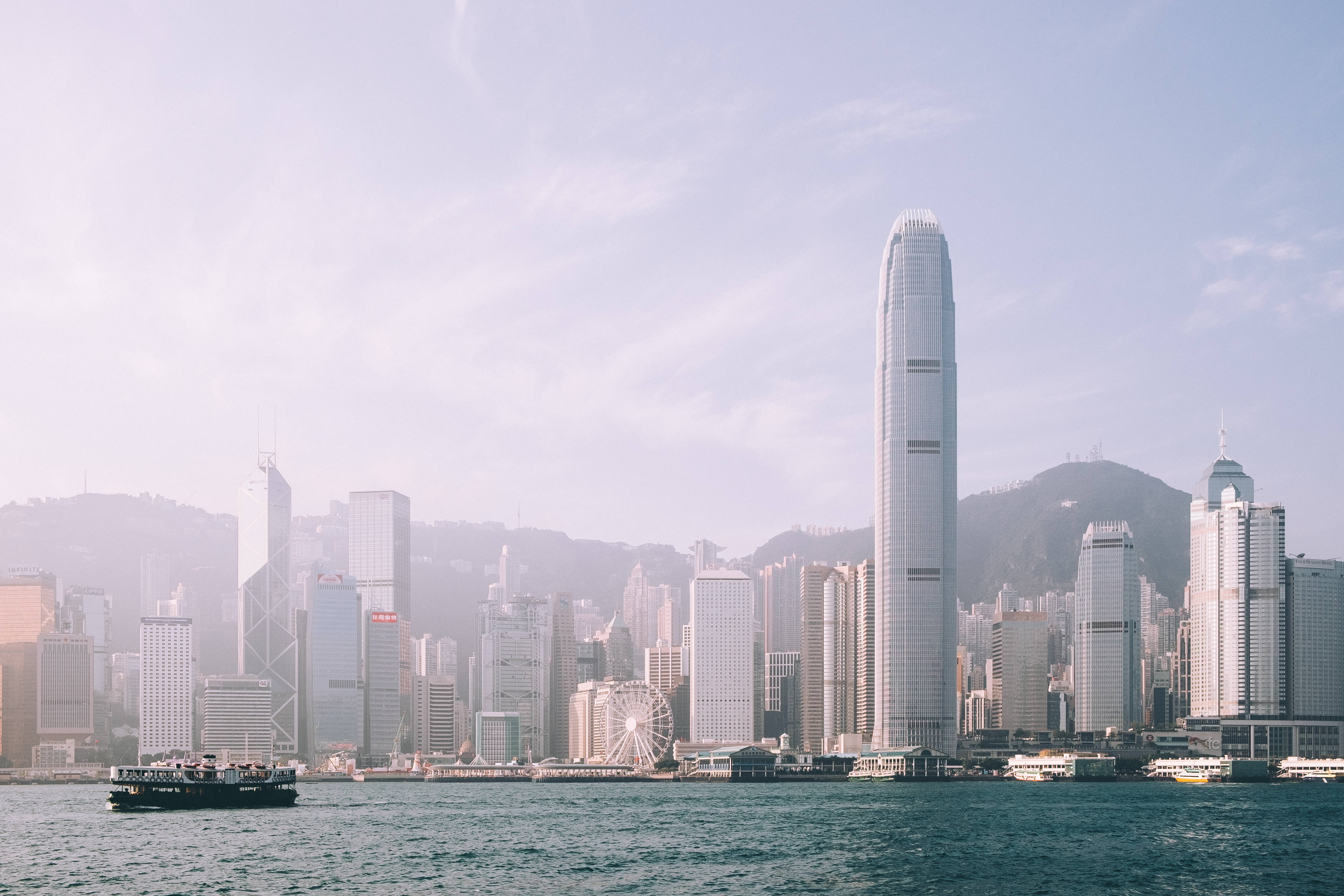 香港 桌布 壁紙 — 香港標誌性天際線的朦朧日間景色，高樓大廈和水上的渡輪。