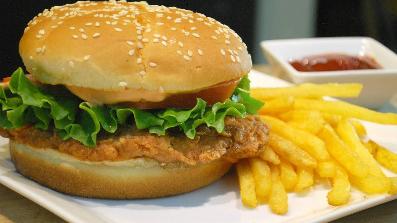 Burger King 桌布 壁紙 — 香脆炸雞漢堡，搭配新鮮生菜、番茄和芝麻麵包，附上金黃薯條和番茄醬。