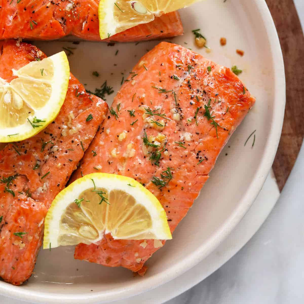 Salmon 桌布 壁紙 — 香脆煎鮭魚排，搭配檸檬片和蒔蘿，盛放在陶瓷盤上。