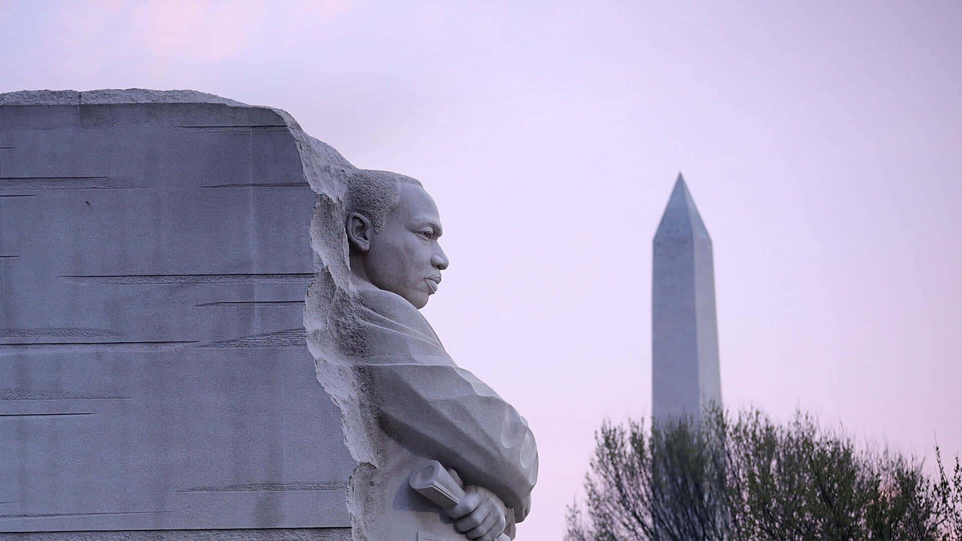Statue Aesthetic 桌布 壁紙 — 馬丁·路德·金的石像側面，華盛頓紀念碑在柔和的暮色天空中可見。