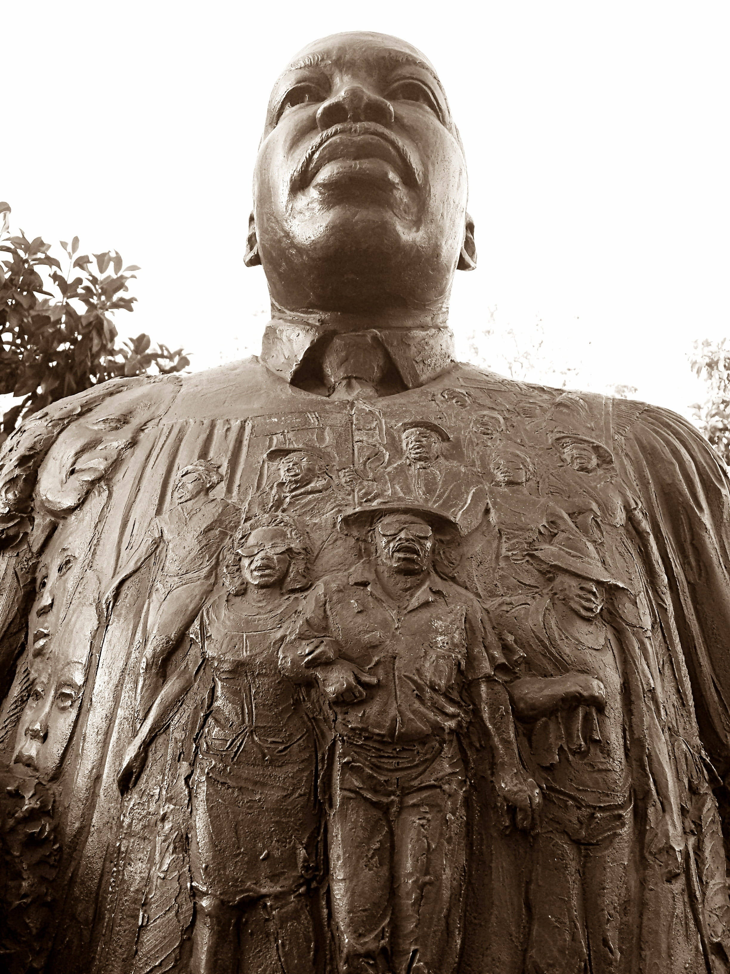 馬丁·路德·金恩 動圖 桌布 壁紙 — 馬丁·路德·金的高聳銅像，胸前有各種抗議者的浮雕雕刻。