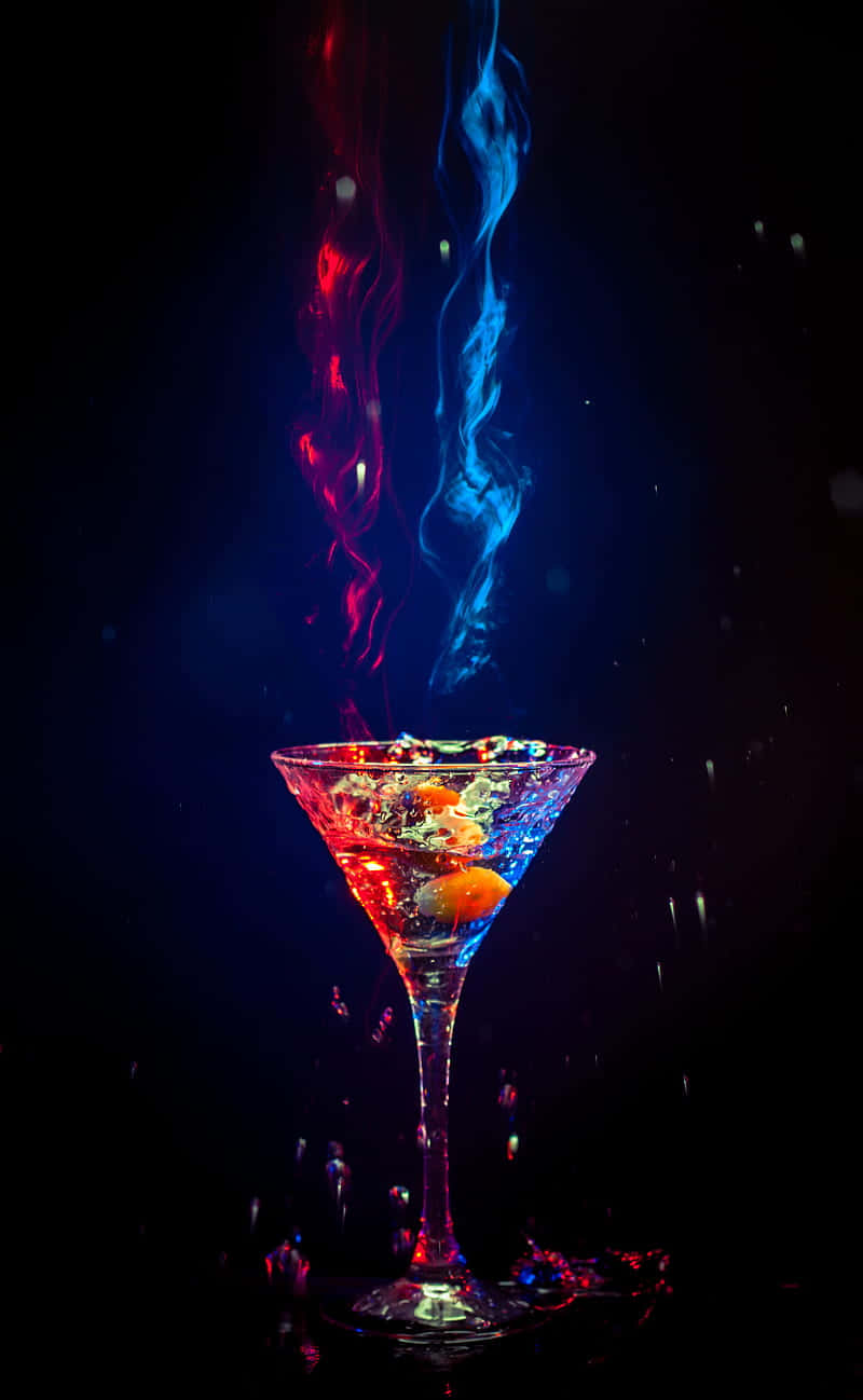 cocktail 桌布 壁紙 — 馬丁尼杯在漆黑背景下噴發出鮮豔的紅色和藍色煙霧。