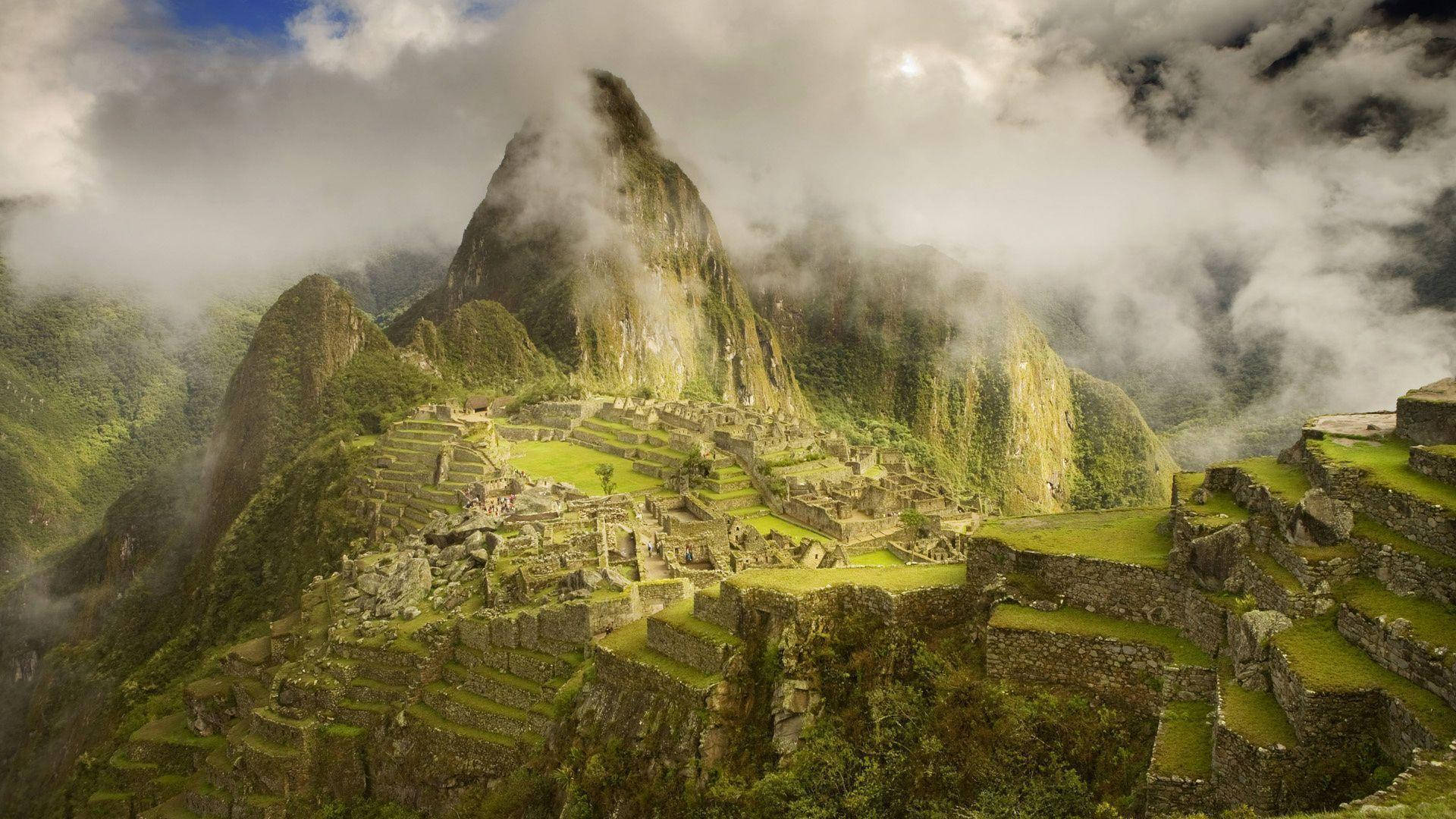 South America 桌布 壁紙 — 馬丘比丘的古老石階梯依附在陰天籠罩下霧氣瀰漫的翠綠山巒上。