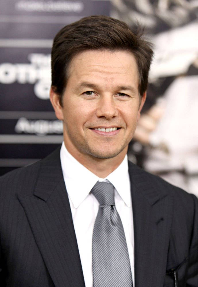 Mark Wahlberg 桌布 壁紙 — 馬克·華伯格在電影首映背景中穿著尖銳的細條紋西裝溫暖地微笑。