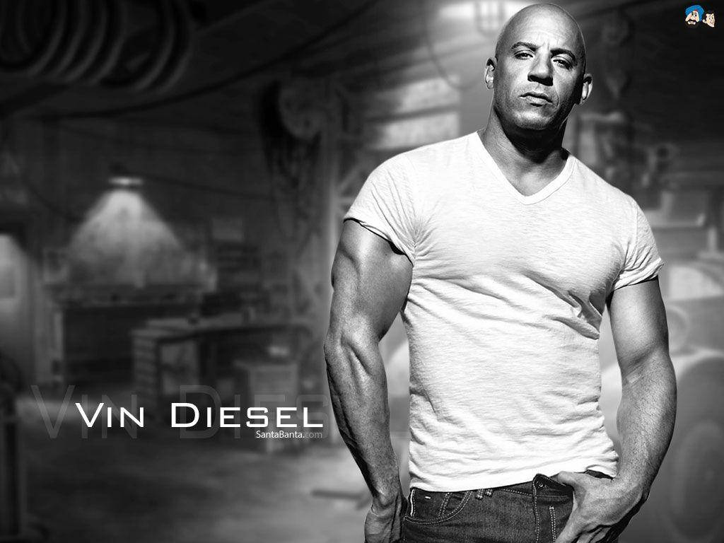 Diesel 桌布 壁紙 — 馮·迪索自信地站在一個骯髒的工作坊，身穿白色T恤和牛仔褲，以戲劇性的黑白肖像呈現。