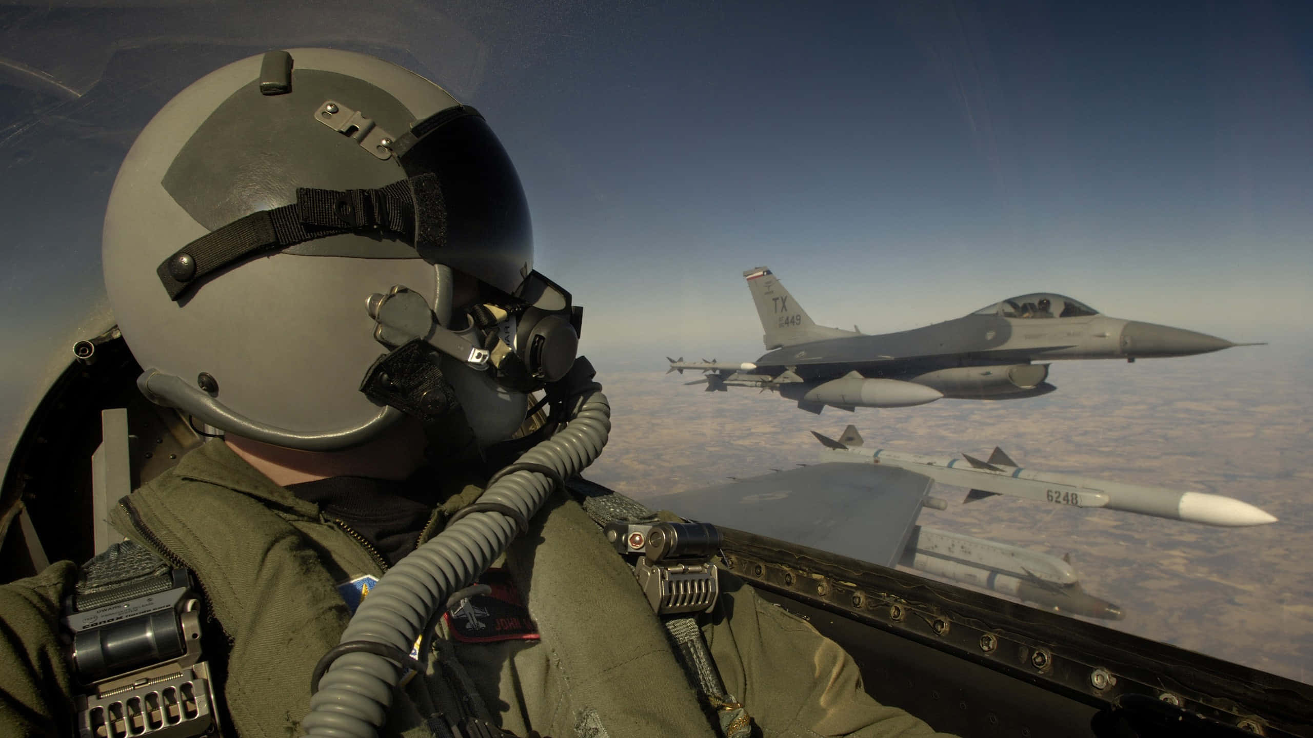 Air Force 桌布 壁紙 — 駕駛艙內的飛行員凝視著在地球表面上方編隊飛行的另一架戰鬥機。